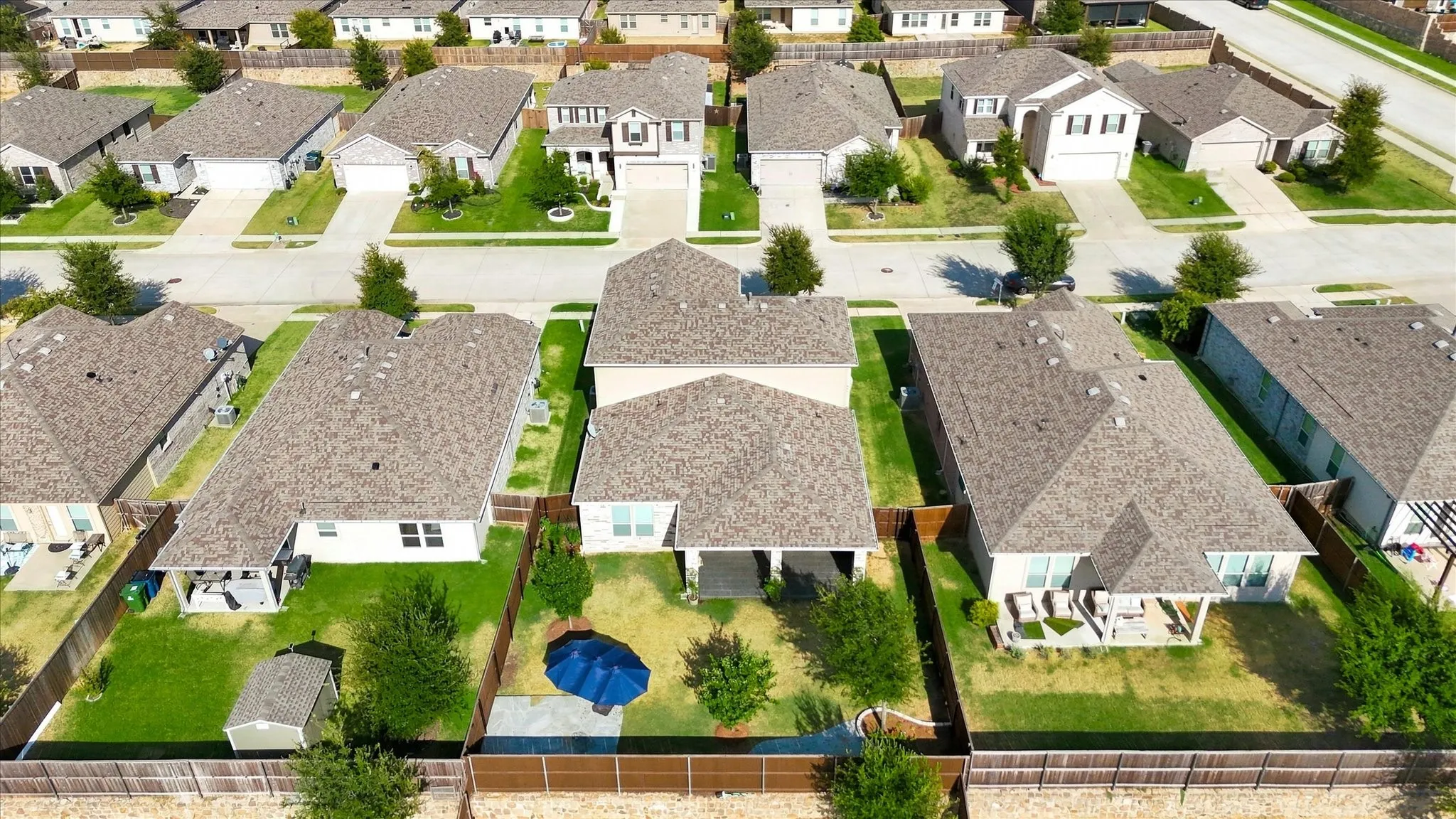 Manicured lawns, mature trees, privacy fencing, covered patio, and storage shed