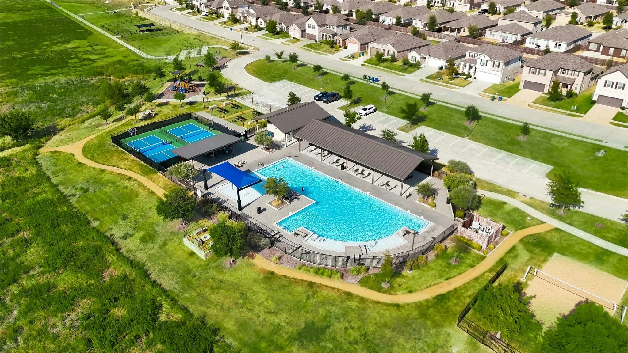 Community recreation center featuring a swimming pool, covered lounge areas, and sports courts
