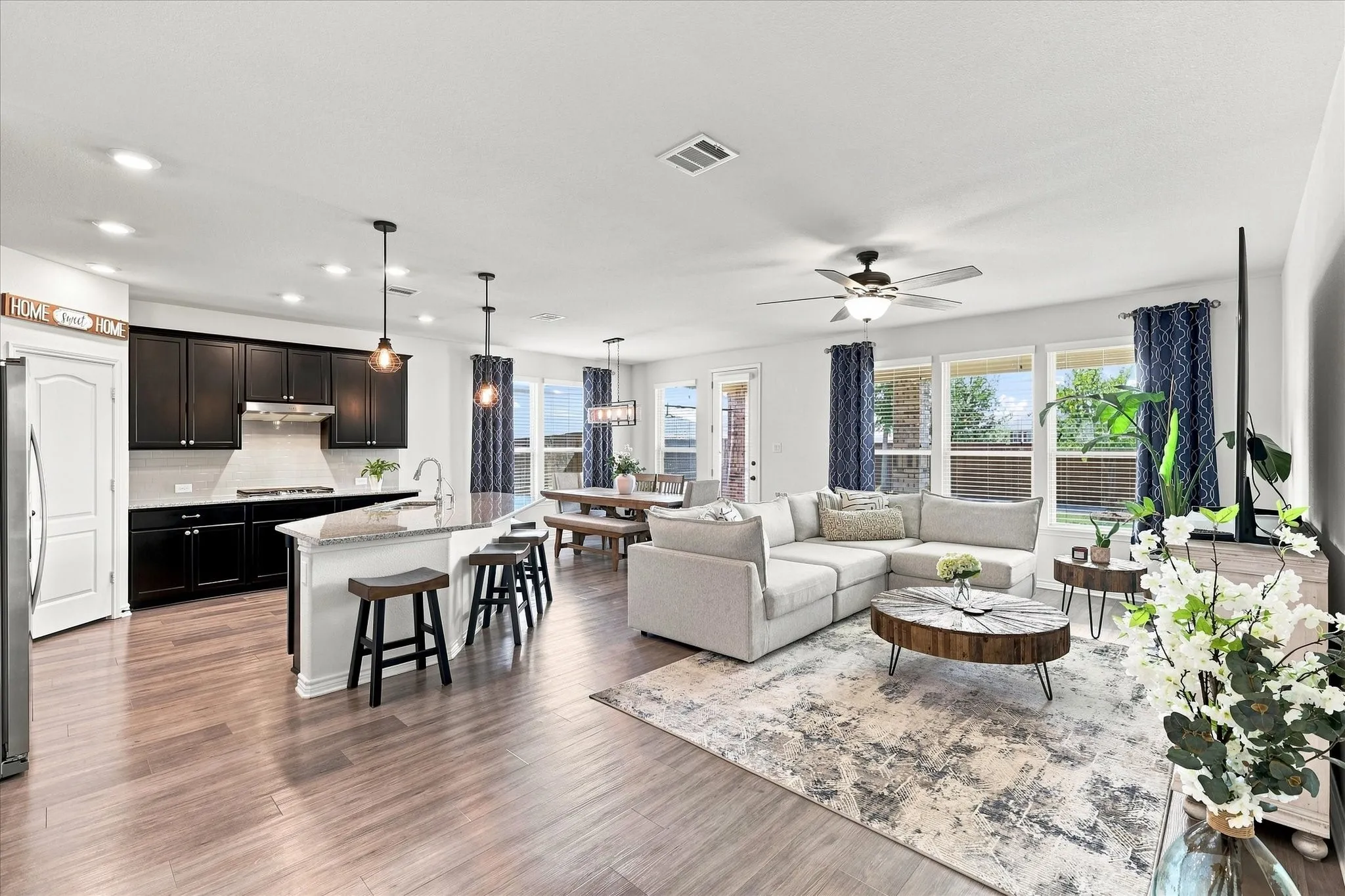 Open-concept living space featuring wood-finish flooring, recessed lighting, and a ceiling fan