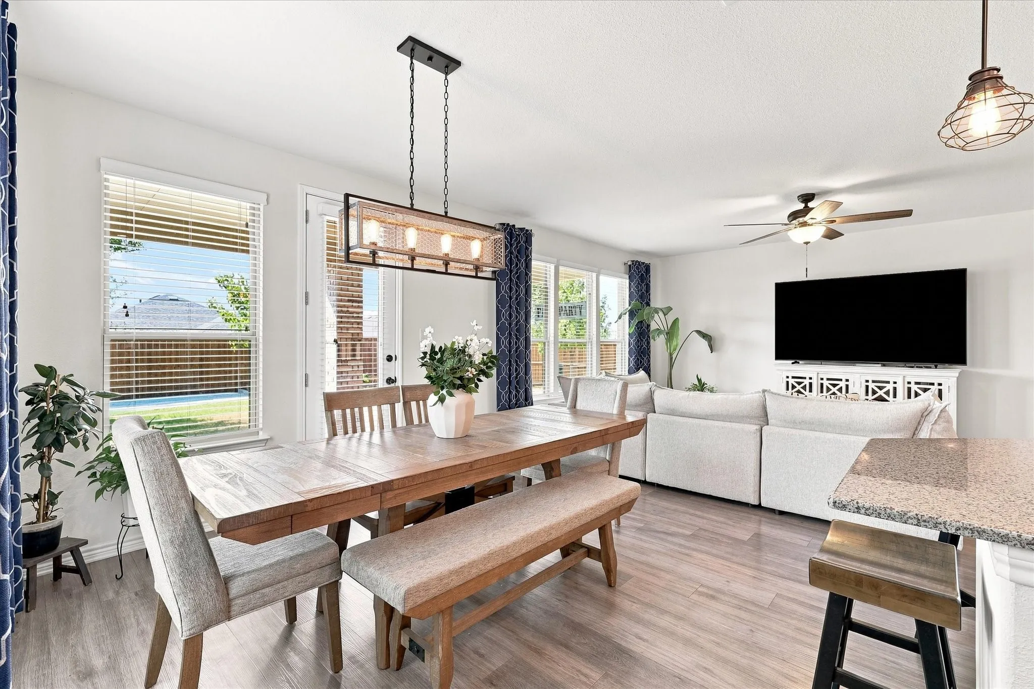 Open concept living space featuring wood-finish flooring, a contemporary chandelier, a ceiling fan, and sliding glass doors