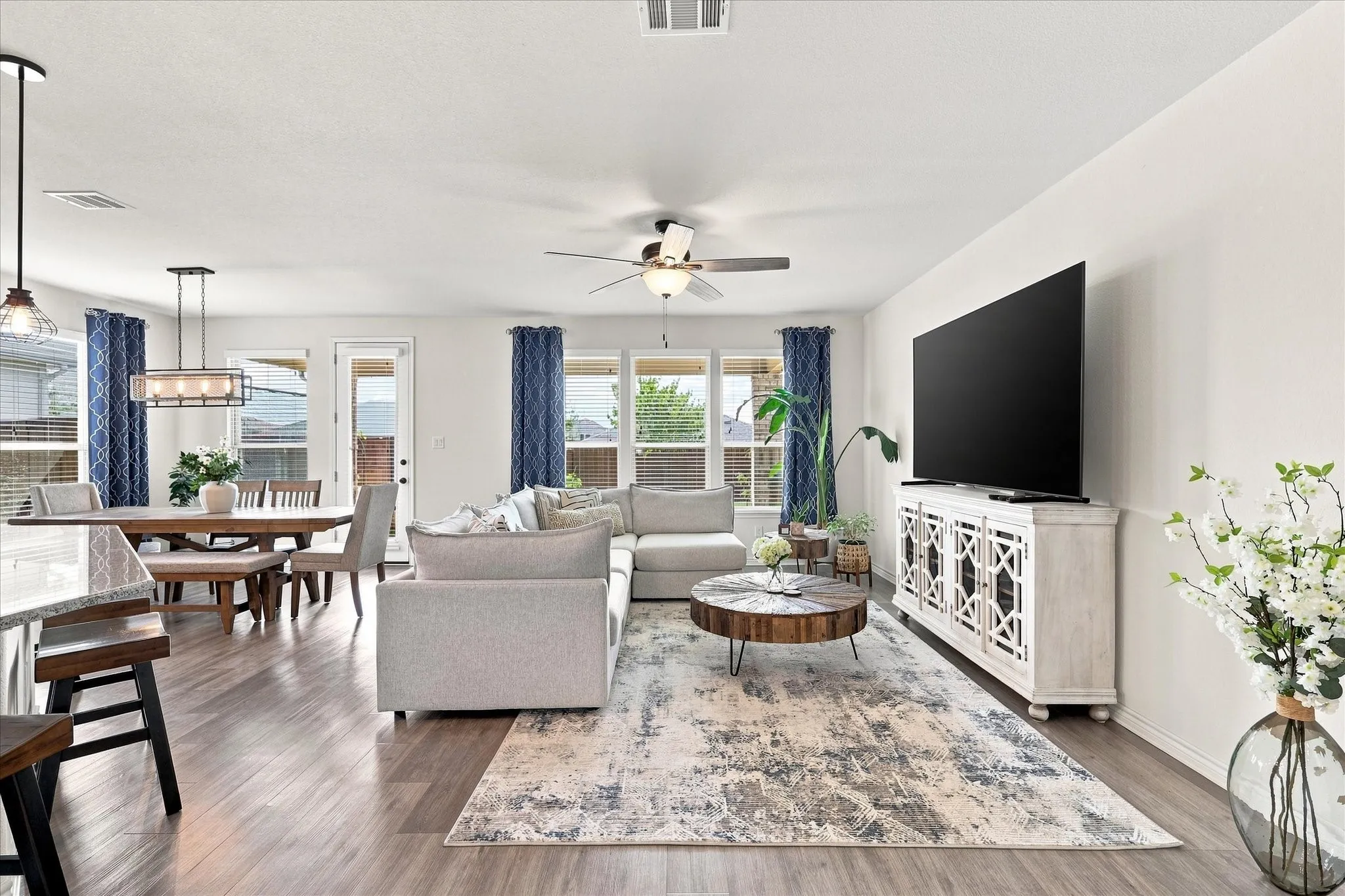 Wood-finish flooring throughout, ceiling fan with integrated lighting, recessed lighting, and multiple large windows