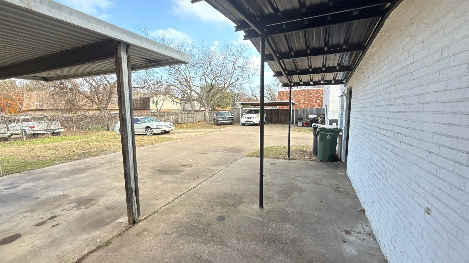 Concrete driveway leading to multiple covered parking structures