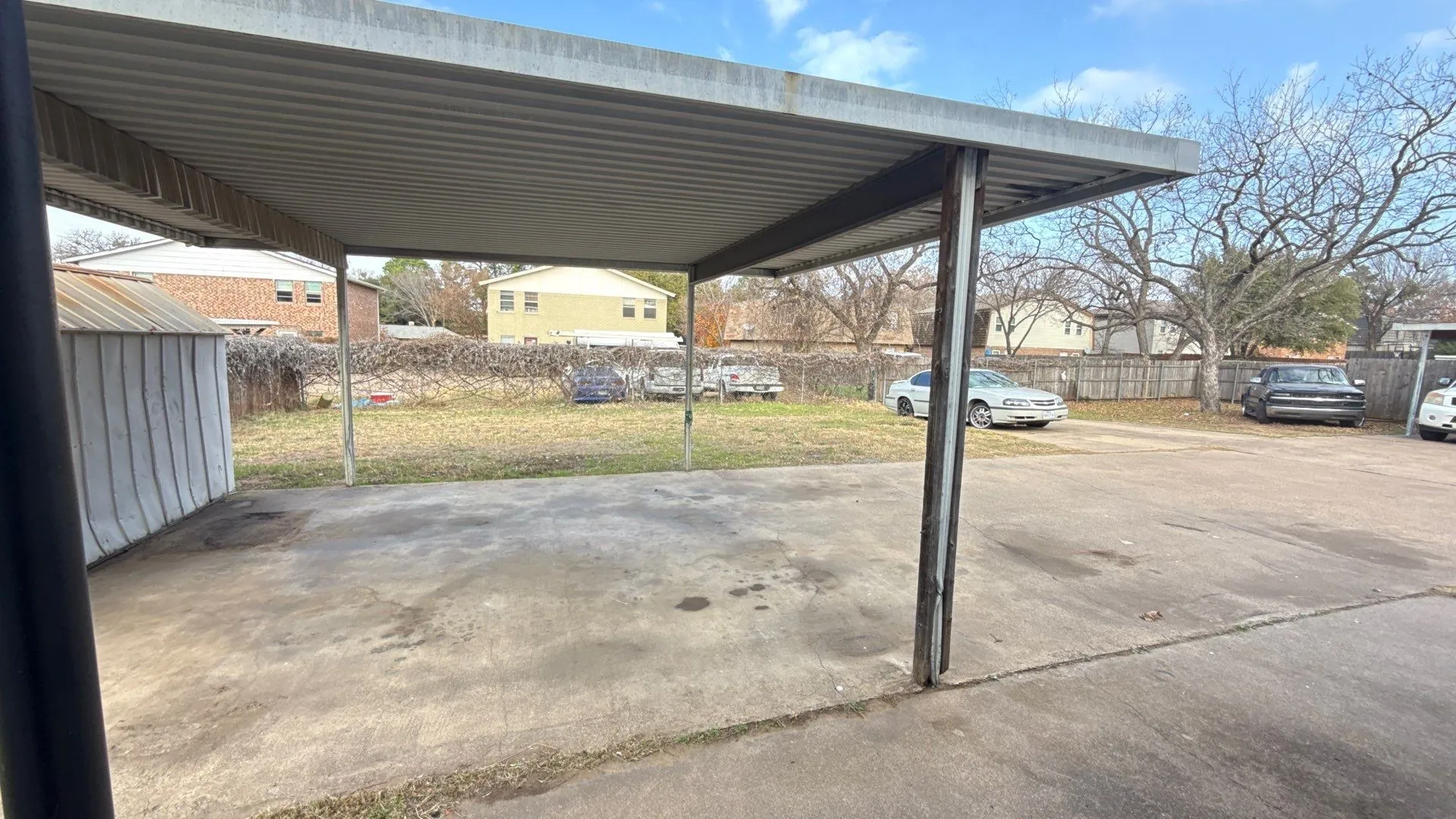 Carport with a corrugated metal roof and support beams