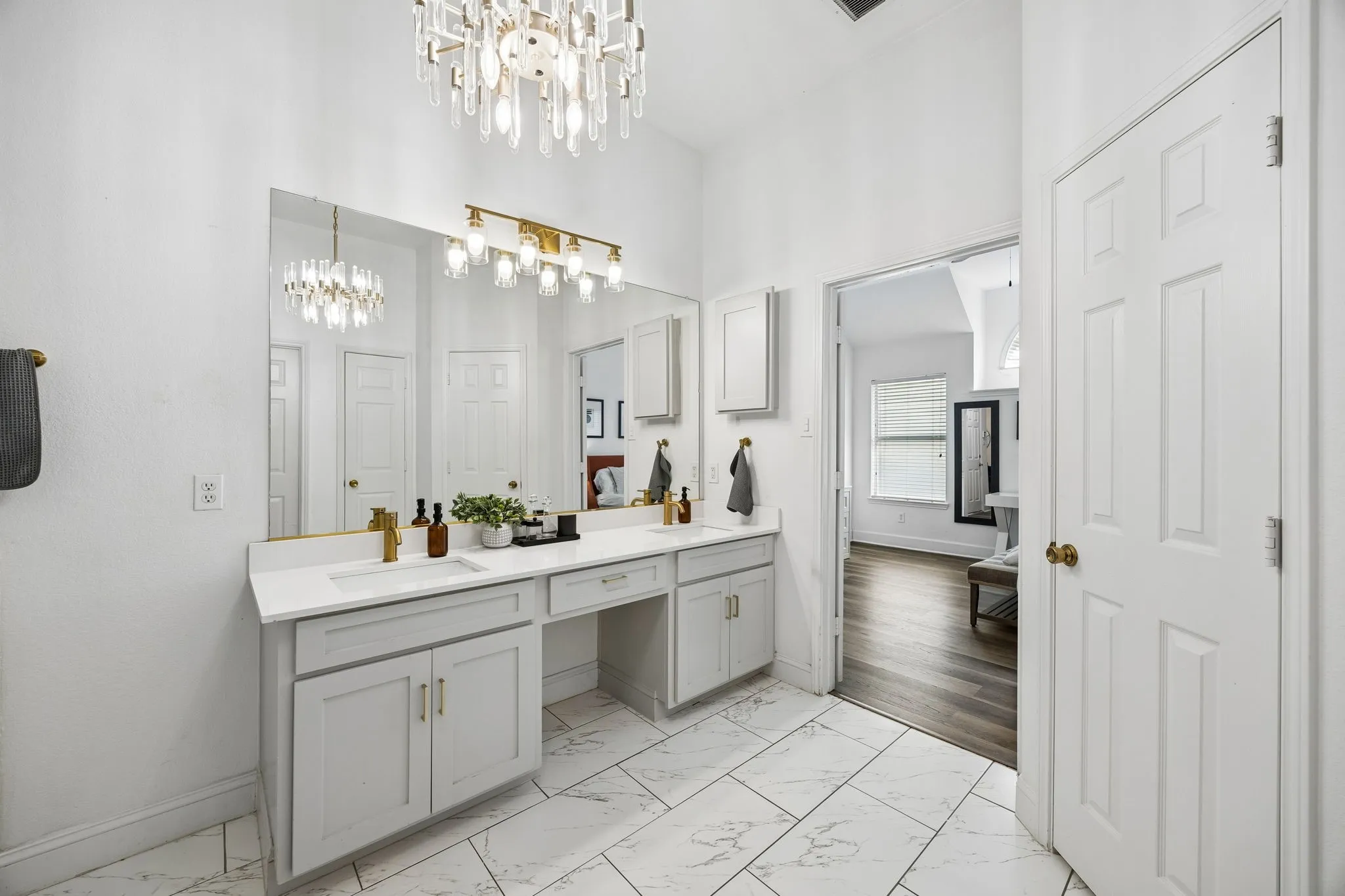 Dual vanity with white countertops, undermount sinks, and gold-finish fixtures