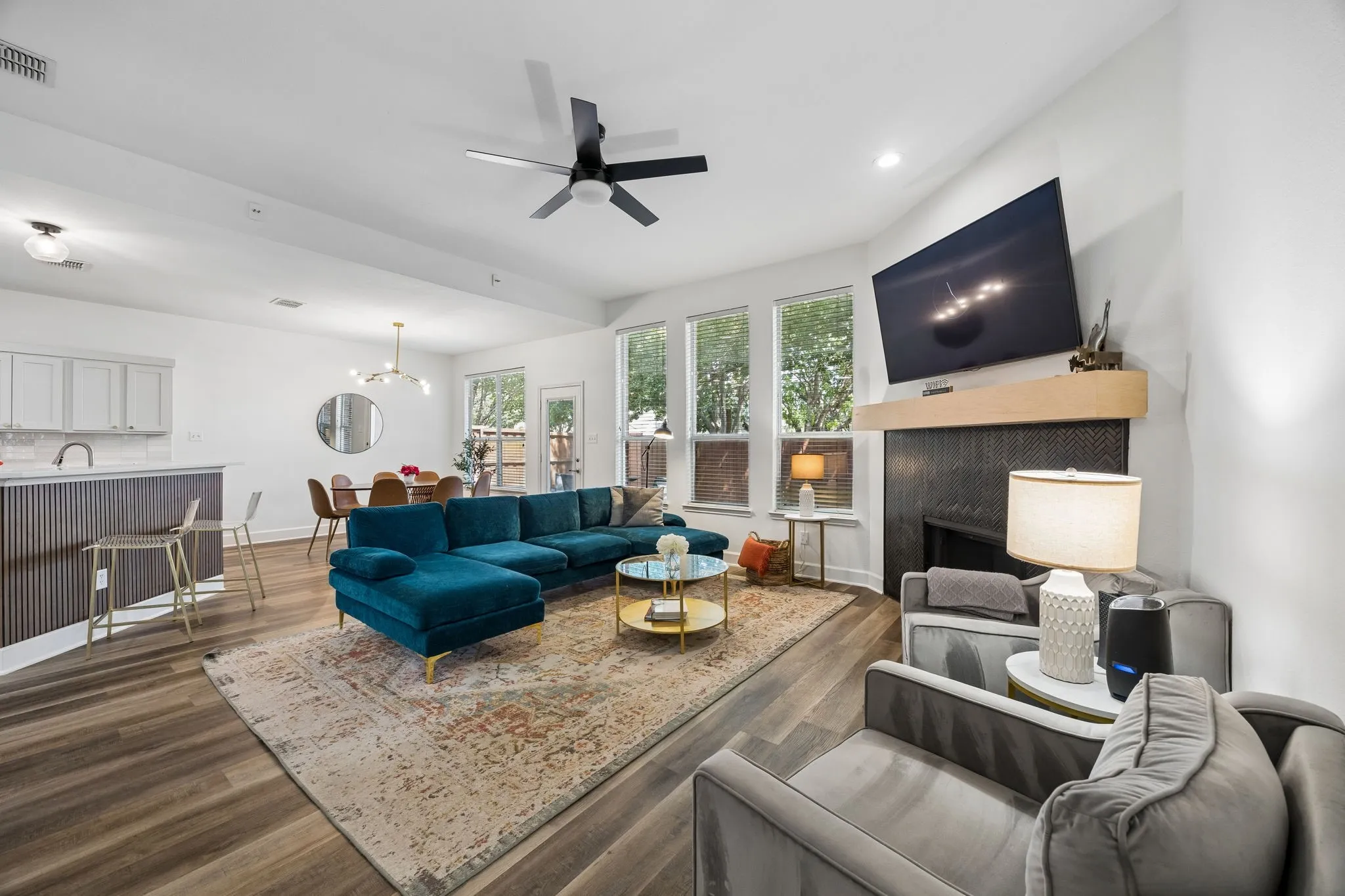 Open-concept living area with wood-finish flooring, recessed lighting, and a contemporary ceiling fan