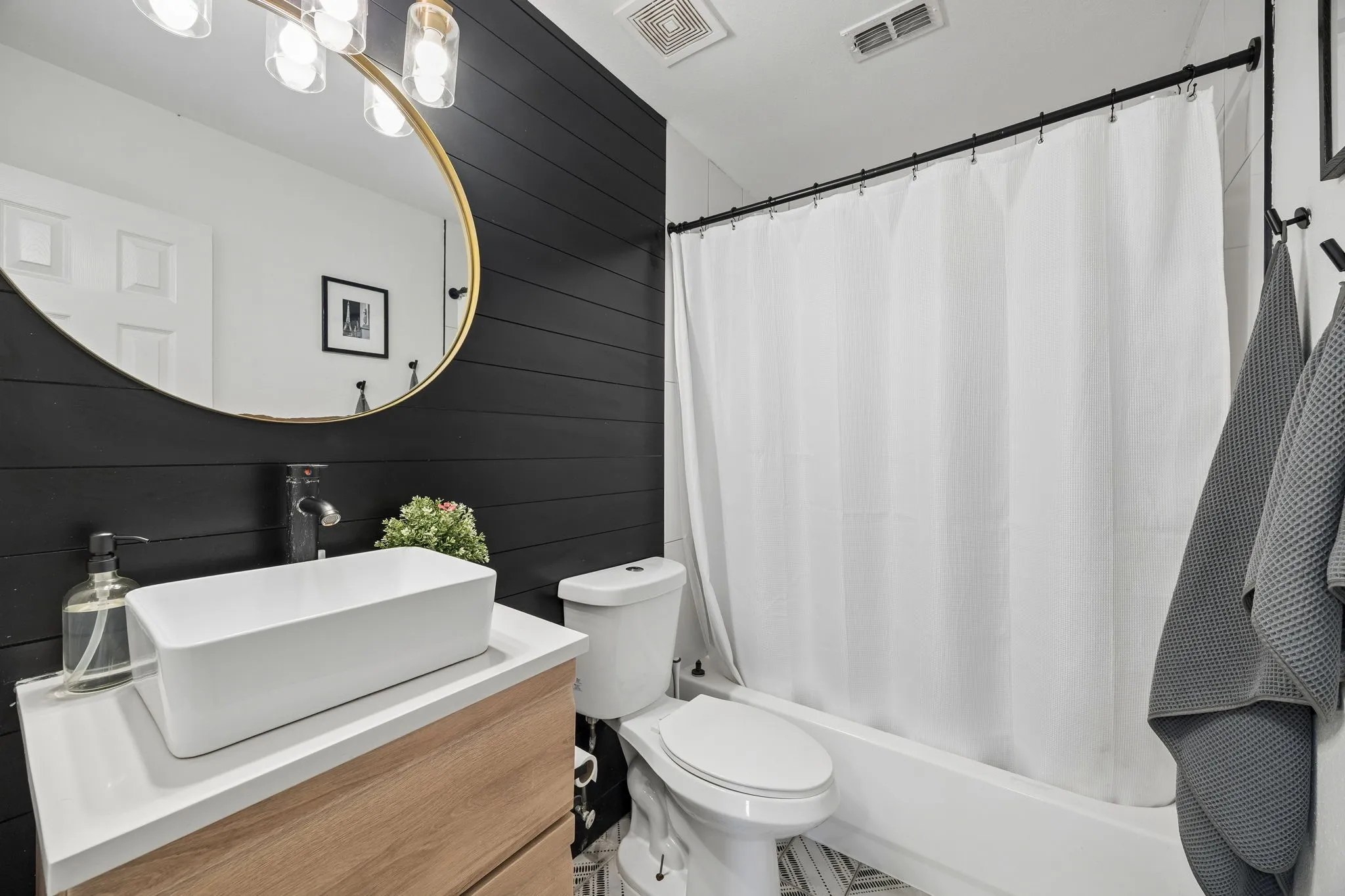 Modern vanity with a rectangular vessel sink, white countertop, and wood-finish cabinetry