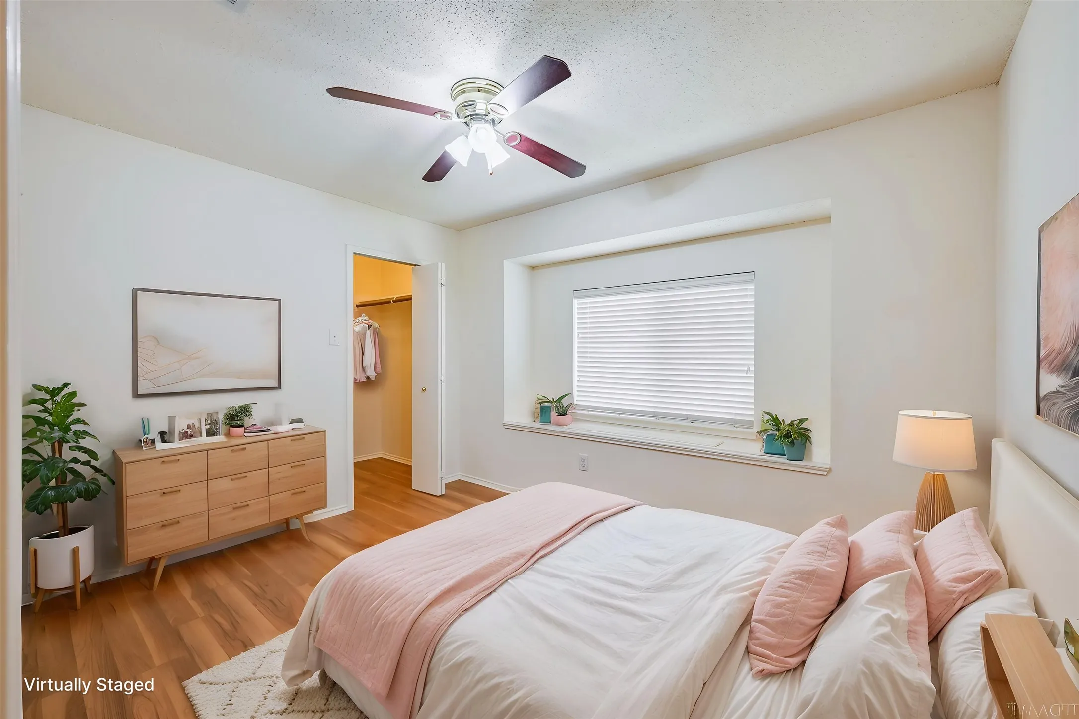 Wood-finish flooring, ceiling fan with integrated lighting, recessed window with blinds, and an open closet entry
