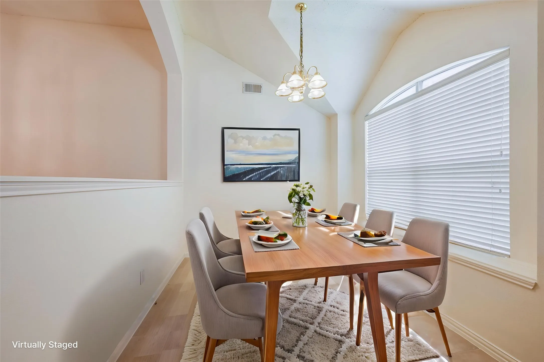 Vaulted ceiling with an arched window, wood-finish flooring, and a chandelier
