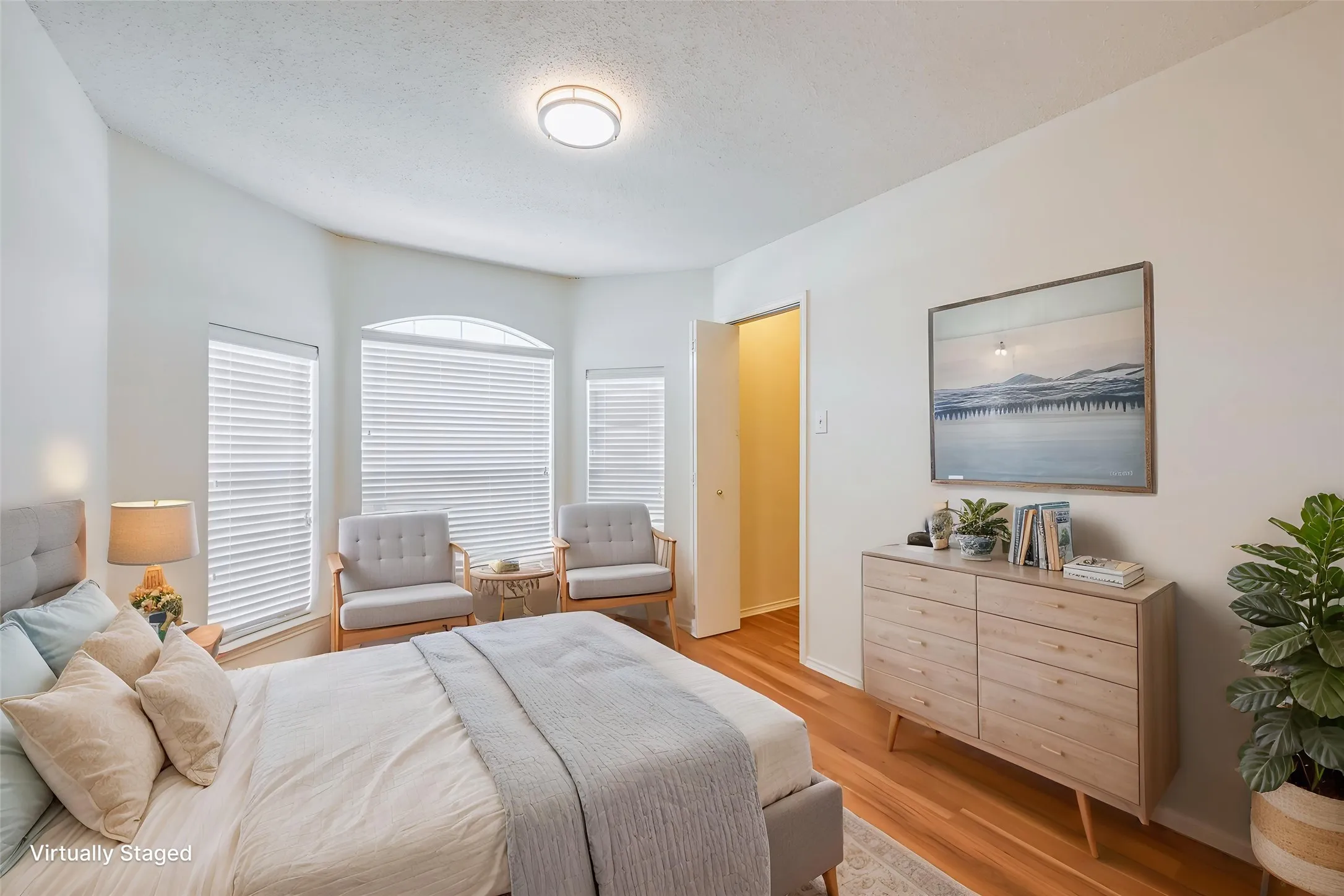 Recessed bay window with multiple paneled windows, wood-finish flooring, and a flush mount ceiling light