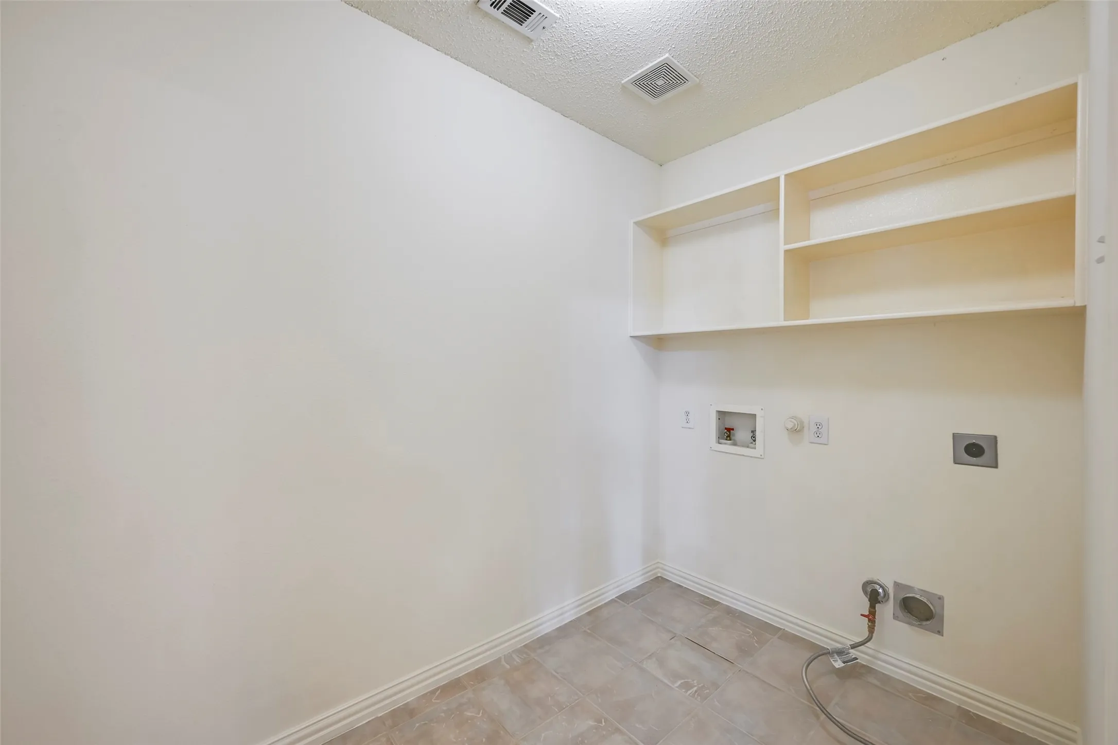 Built-in shelving, tile flooring, washer hookup, and dryer hookup