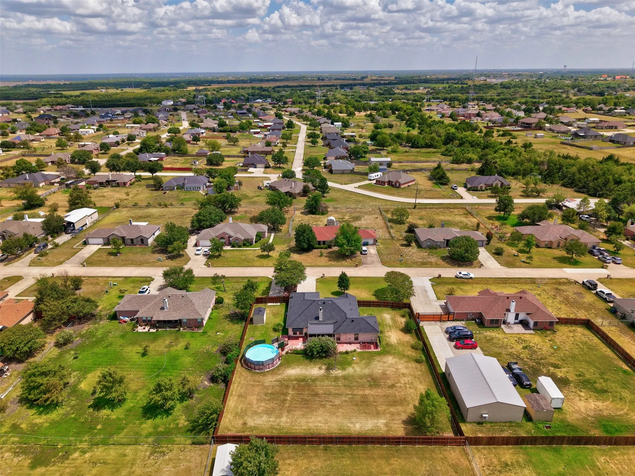 Property features a single-story residence, detached outbuilding, a circular above-ground pool and featuring 2 long driveways