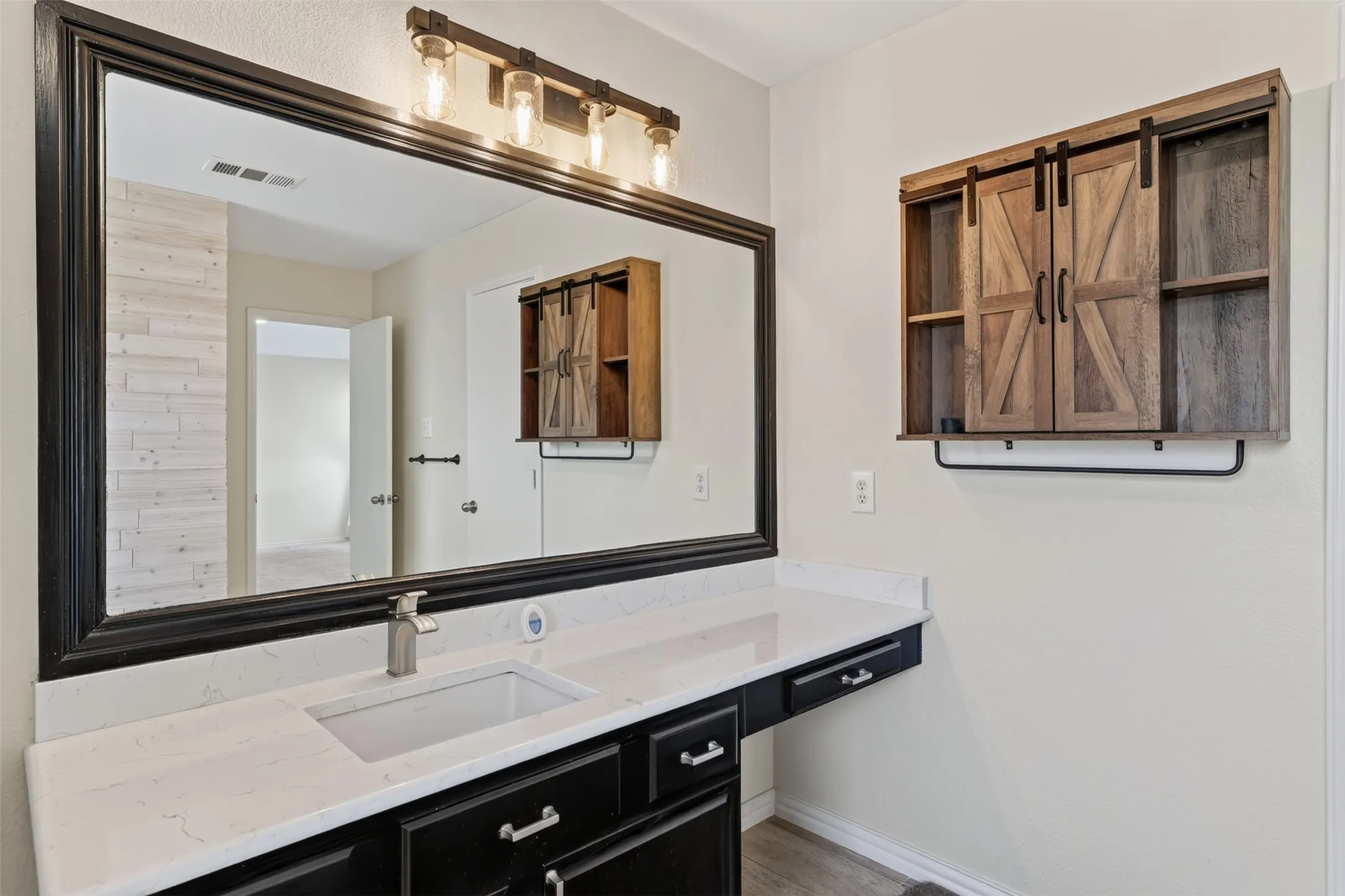 Primary bath with oversized vanity with a rectangular undermount sink, a white granite countertop, dark wood-finish cabinets, plus a medicine cabinet