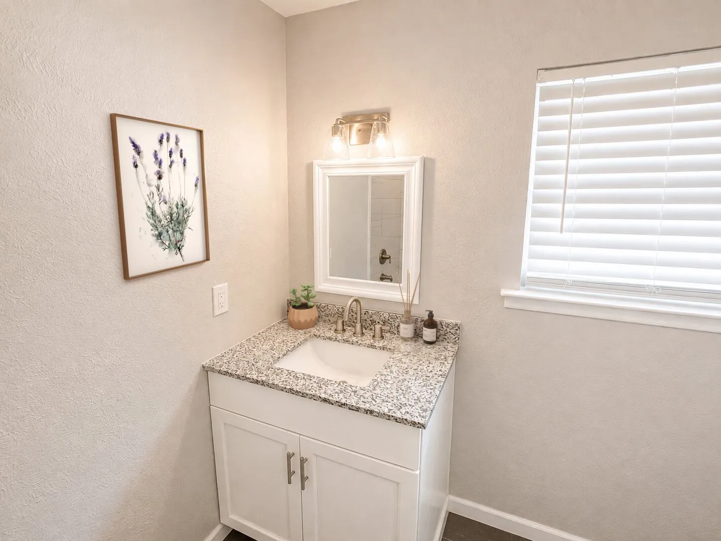 Virtually staged
Vanity with a granite-style countertop, undermount sink, and brushed nickel faucet