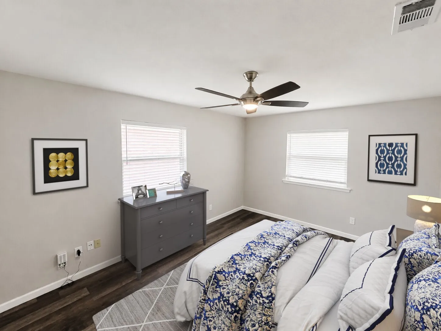 Virtually staged
Wood-finish flooring, light-toned wall paint, two windows with blinds, and a ceiling fan with integrated lighting