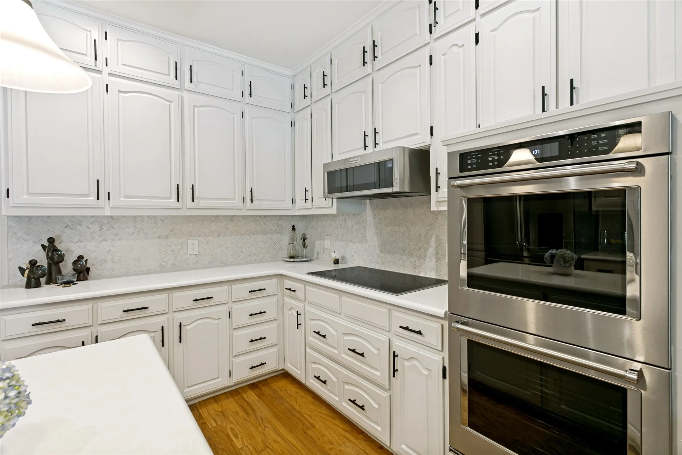 Sophisticated quartz countertops and Carrara marble backsplash are stand-out features for this elegant kitchen.