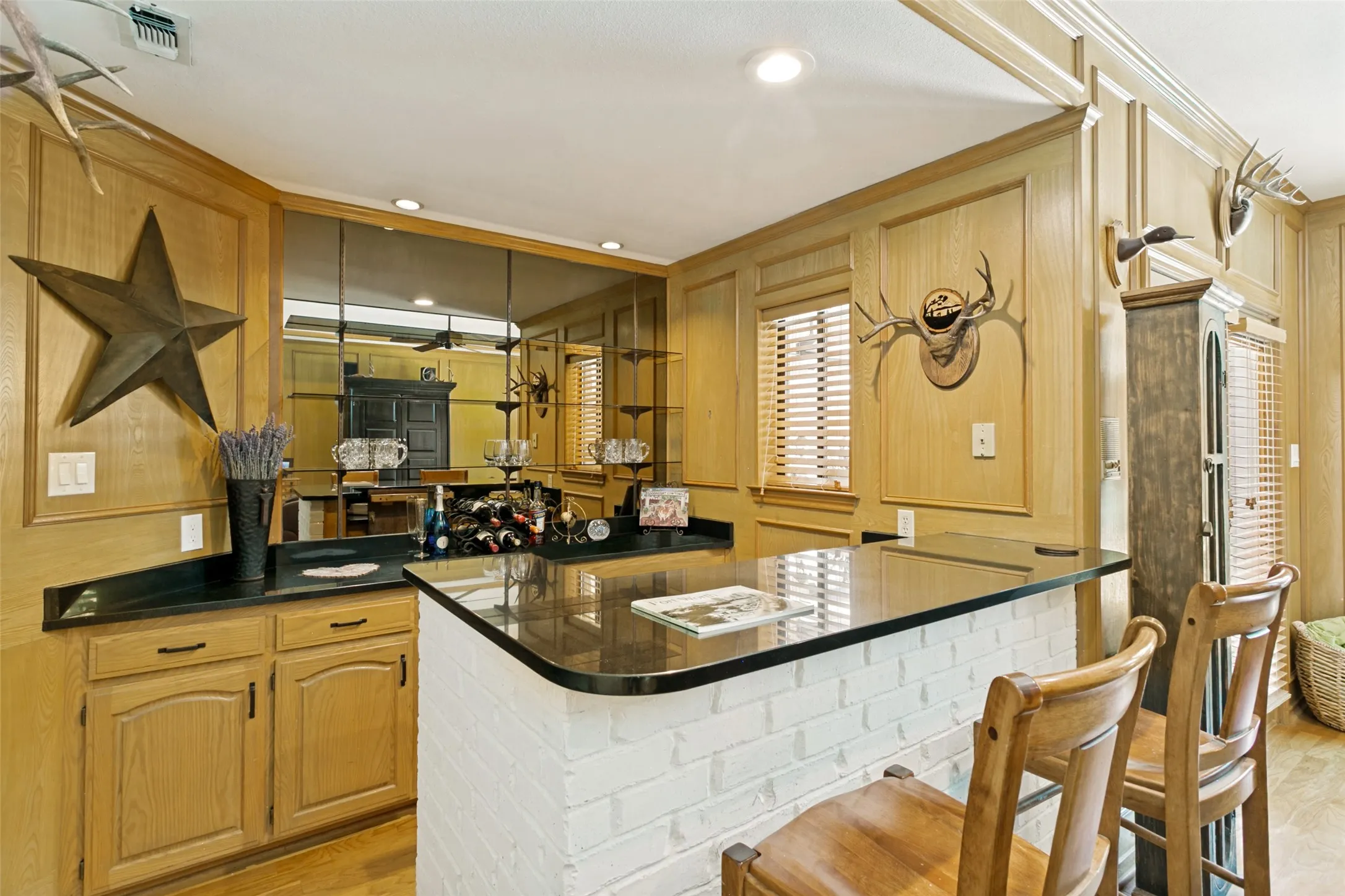 A built-in serving area with black granite countertops adds both storage and convenience for entertaining.