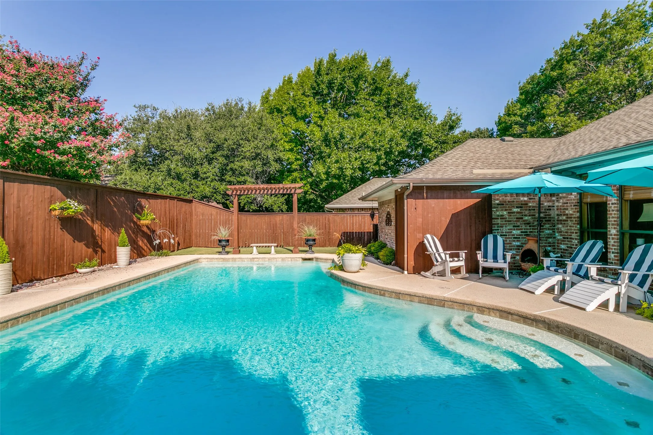 The pristine pool is the centerpiece of an inviting outdoor living area.