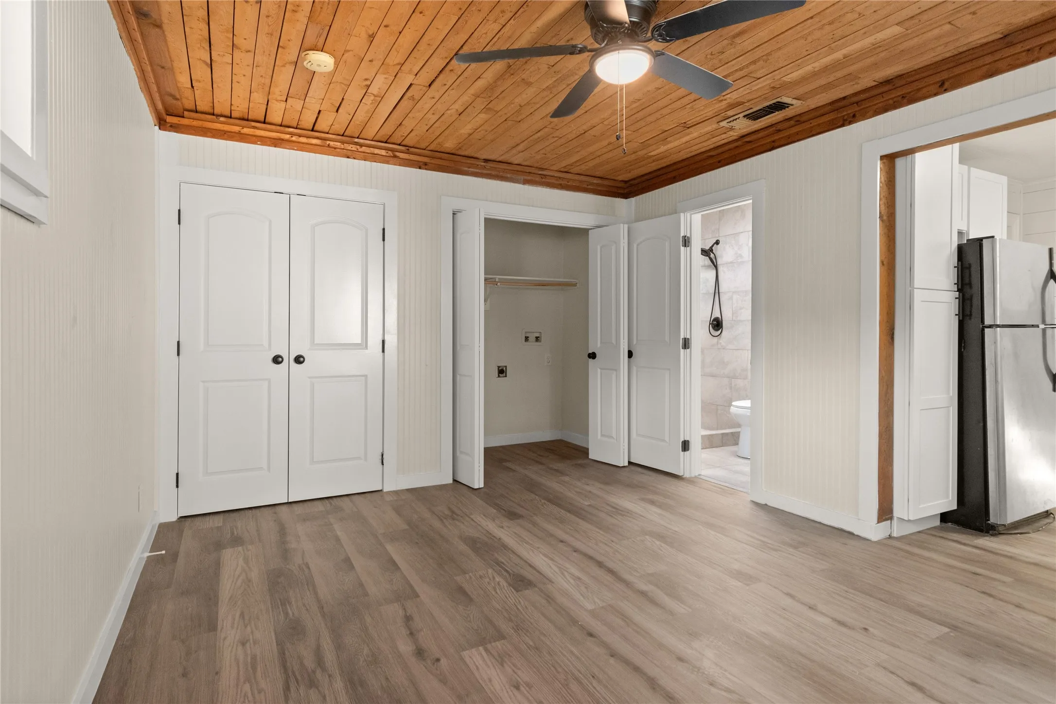 3rd bedroom or flex space. LVP flooring, wood plank ceiling, closet, laundry room and full-bathroom.