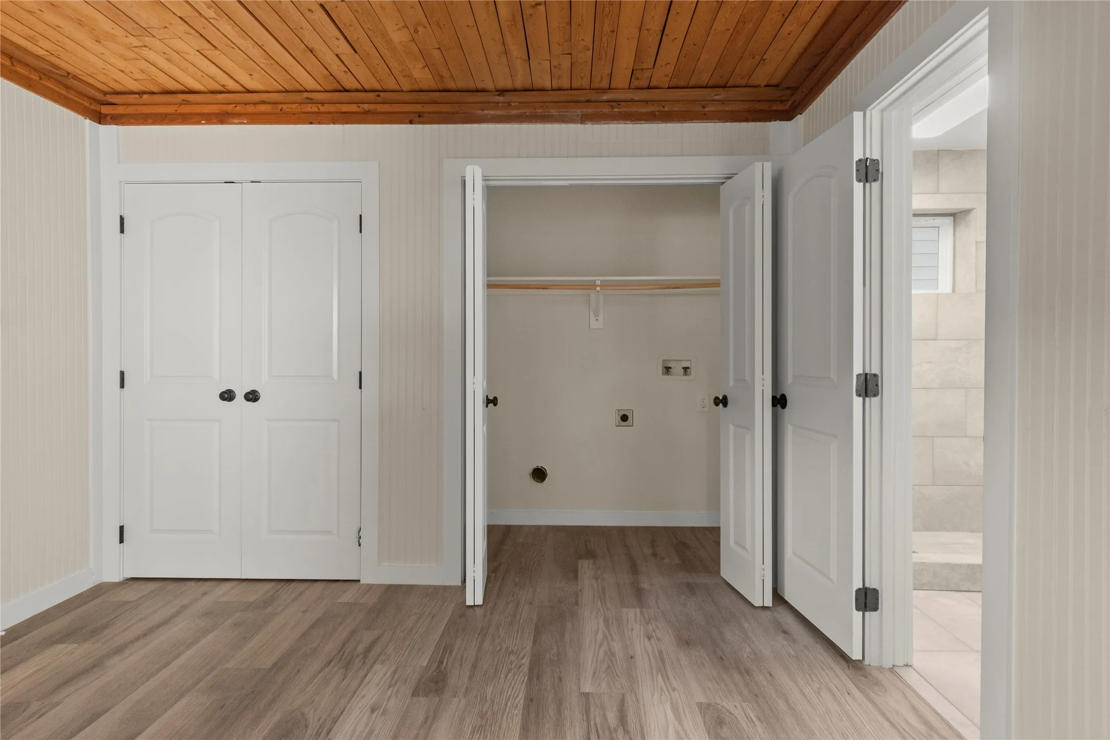 3rd bedroom or flex space. LVP flooring, wood plank ceiling, closet, laundry room and full-bathroom.