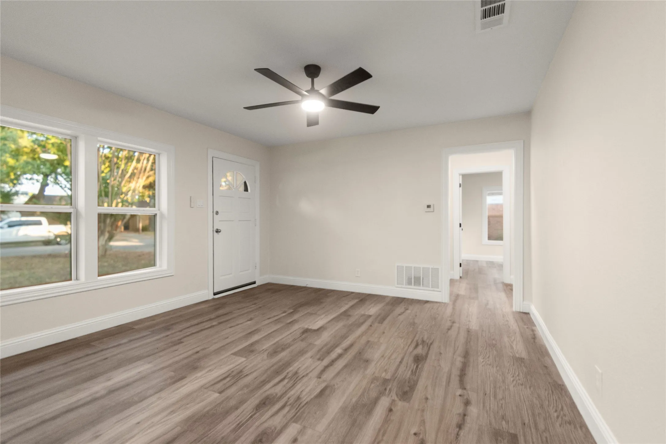View from the dining room into the living room. View into short hallway to the bedrooms