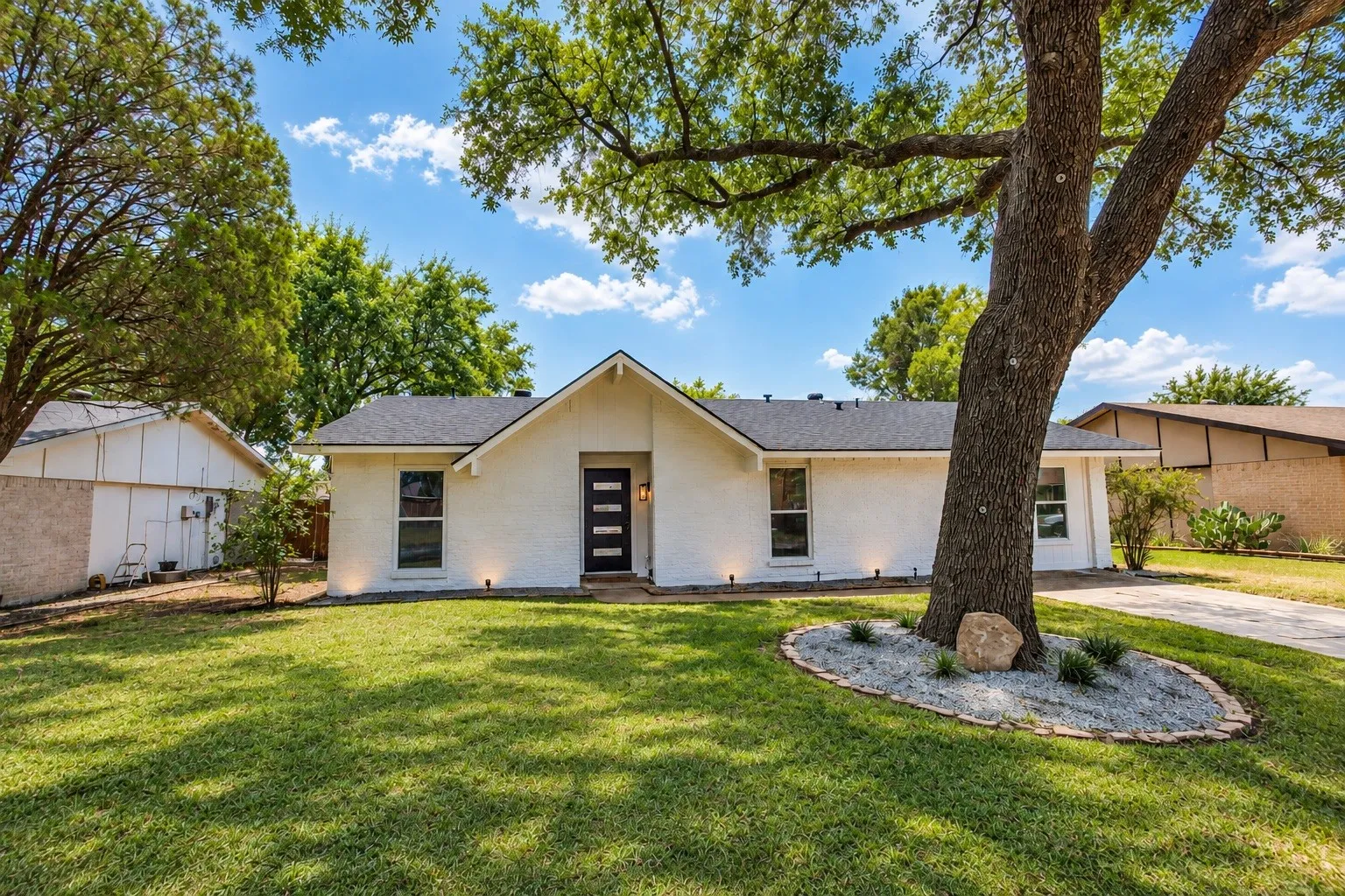 White painted brick exterior with a black asphalt shingle roof