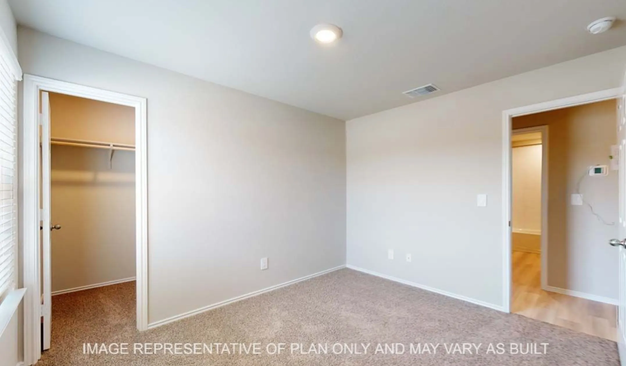 Wall-to-wall carpeting, recessed ceiling lighting, and a window with horizontal blinds