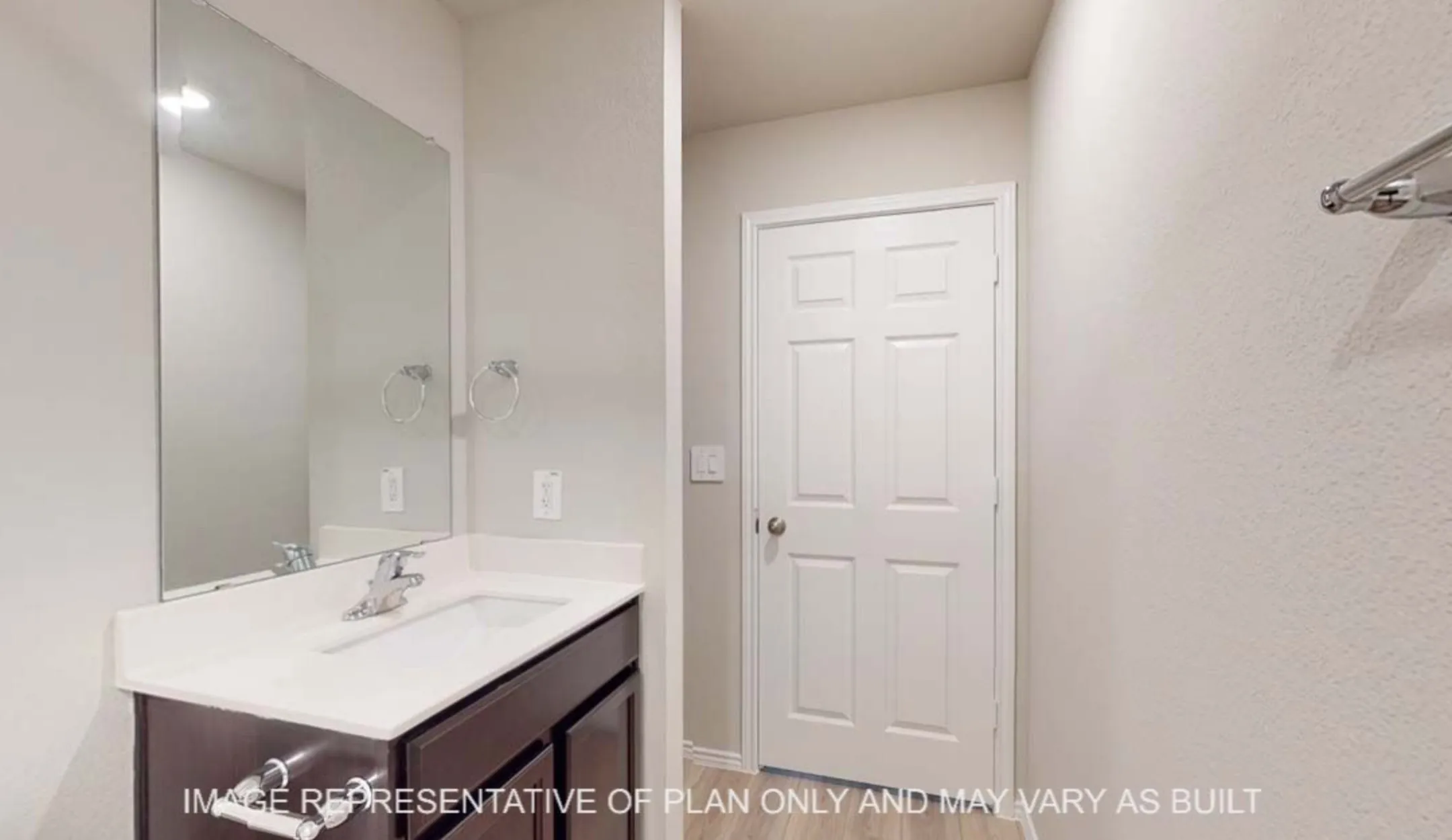 Vanity with integrated sink, chrome faucet, and dark wood-finish cabinetry