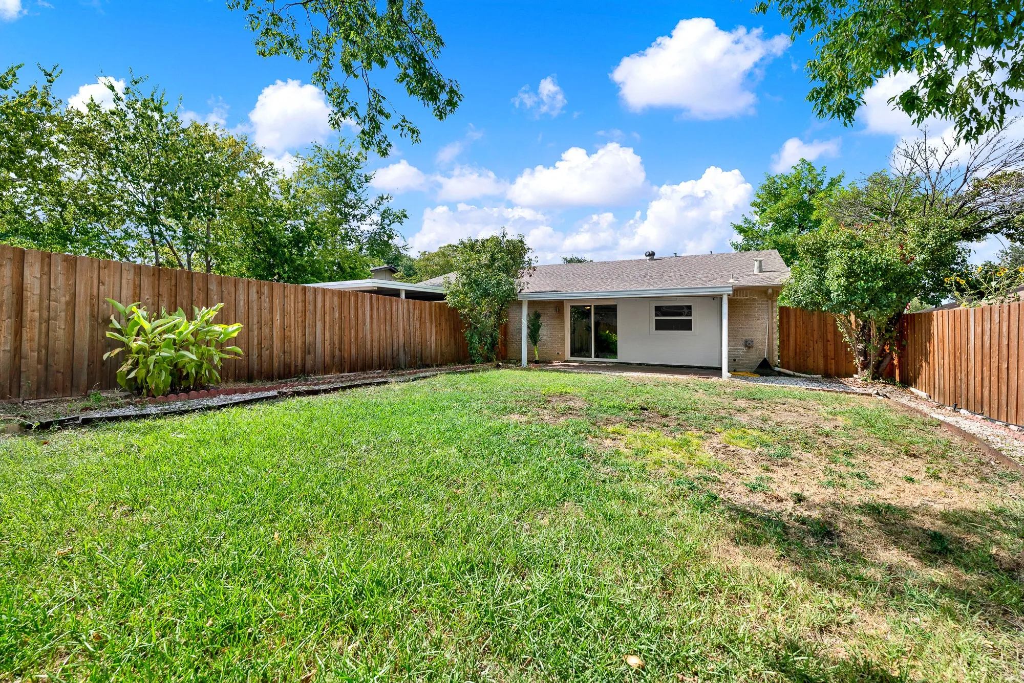 Spacious backyard with covered patio.