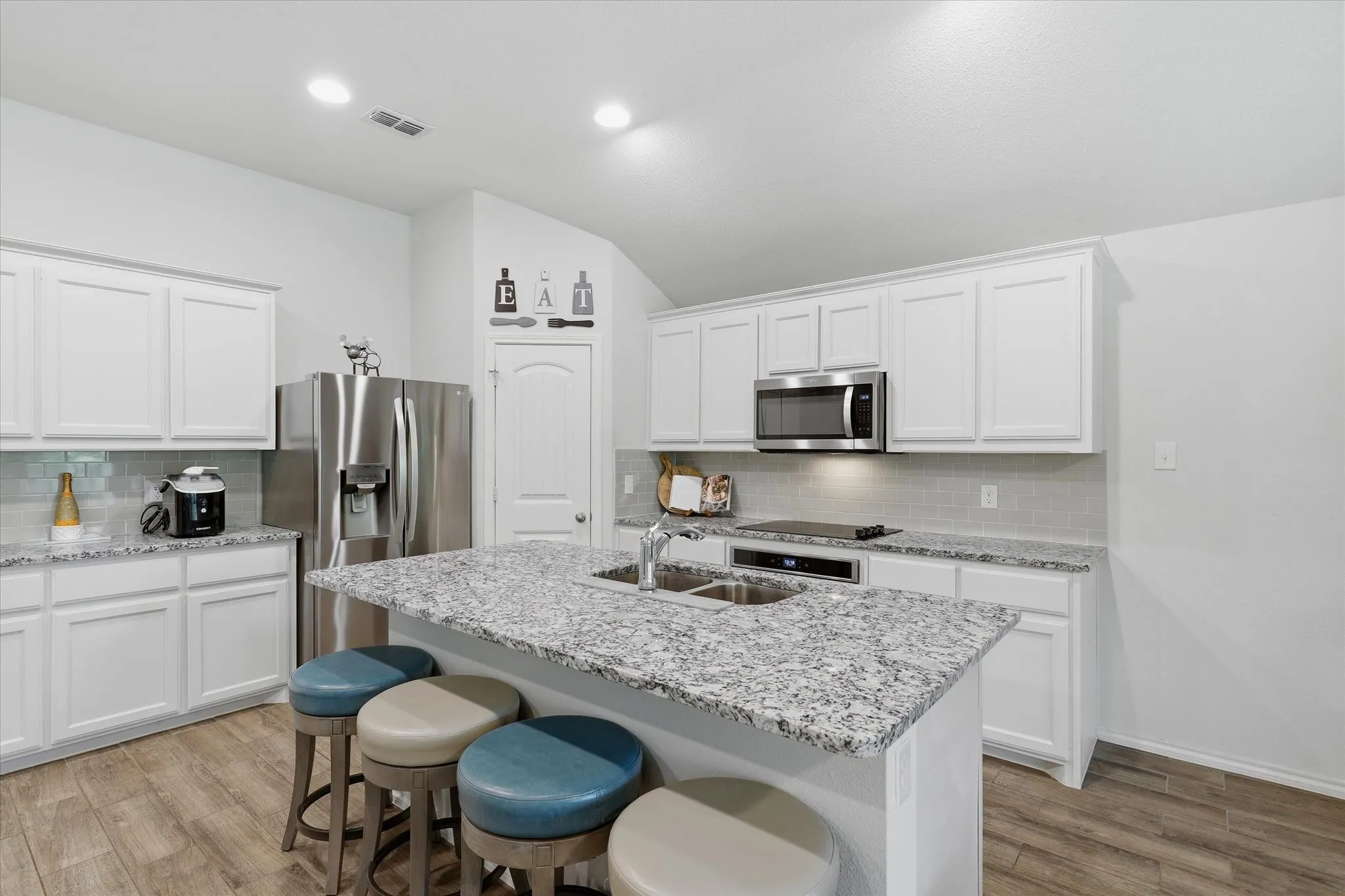 The Kitchen offers granite counter-tops a white backsplash and white cabinets.