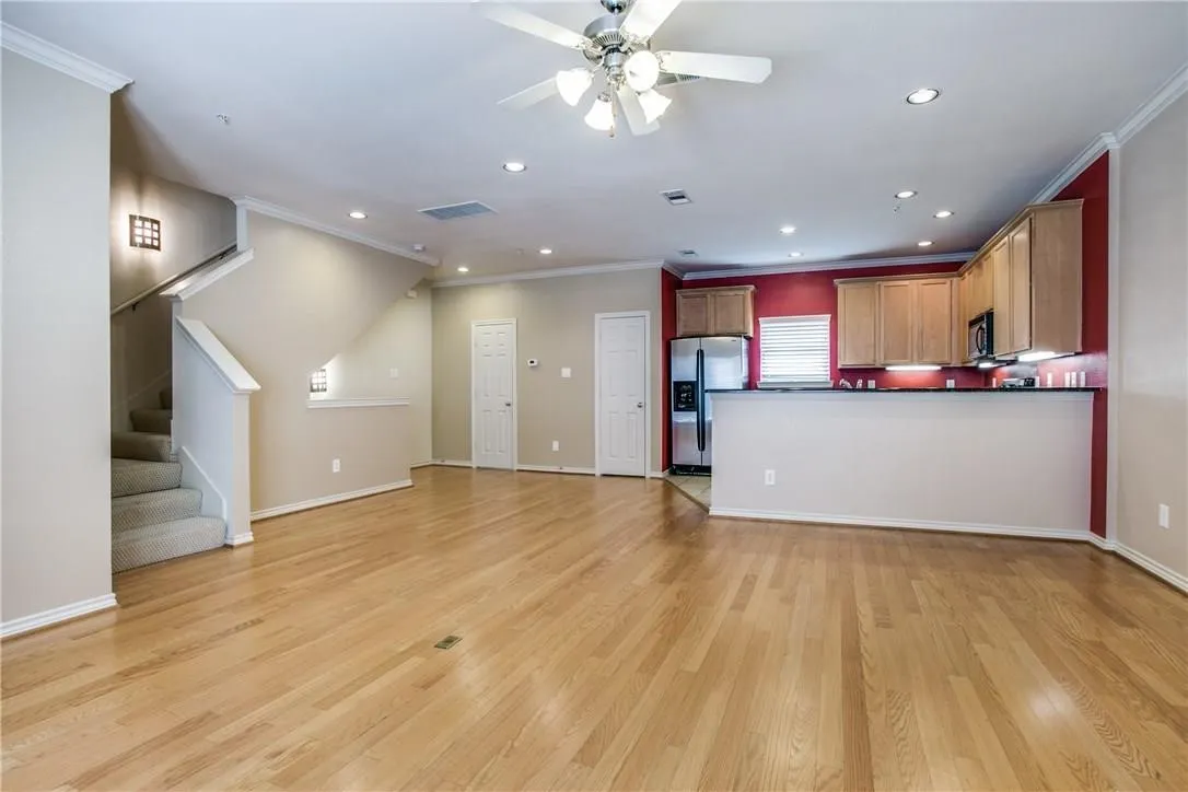 Wood-finish flooring, recessed ceiling lights, and a ceiling fan with light fixture