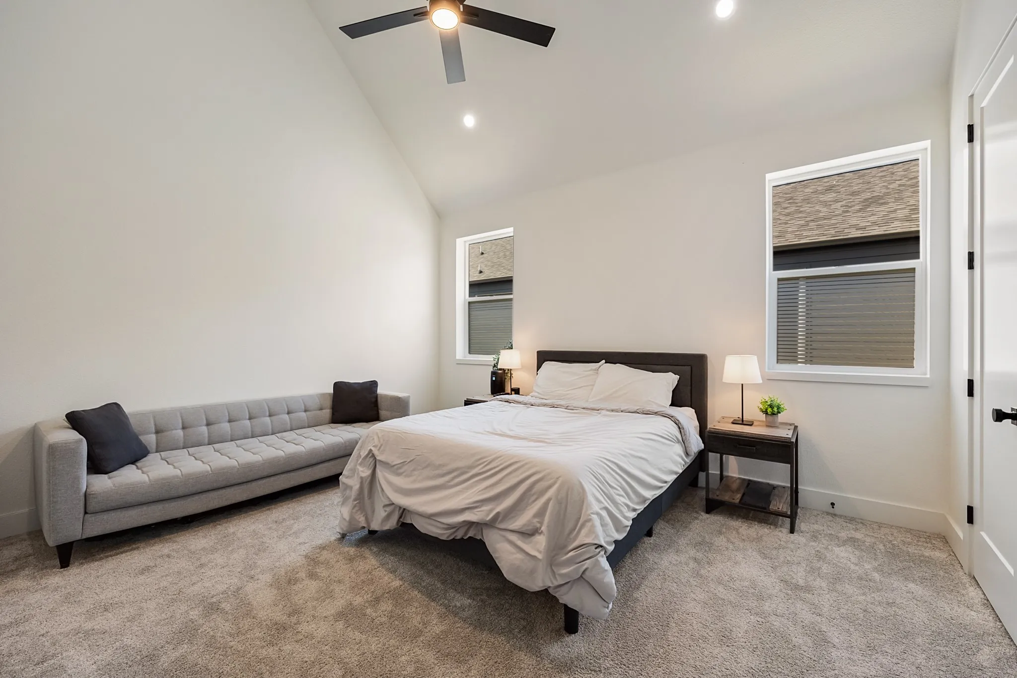 Vaulted ceiling, recessed lighting, ceiling fan, white trim, and carpeted flooring