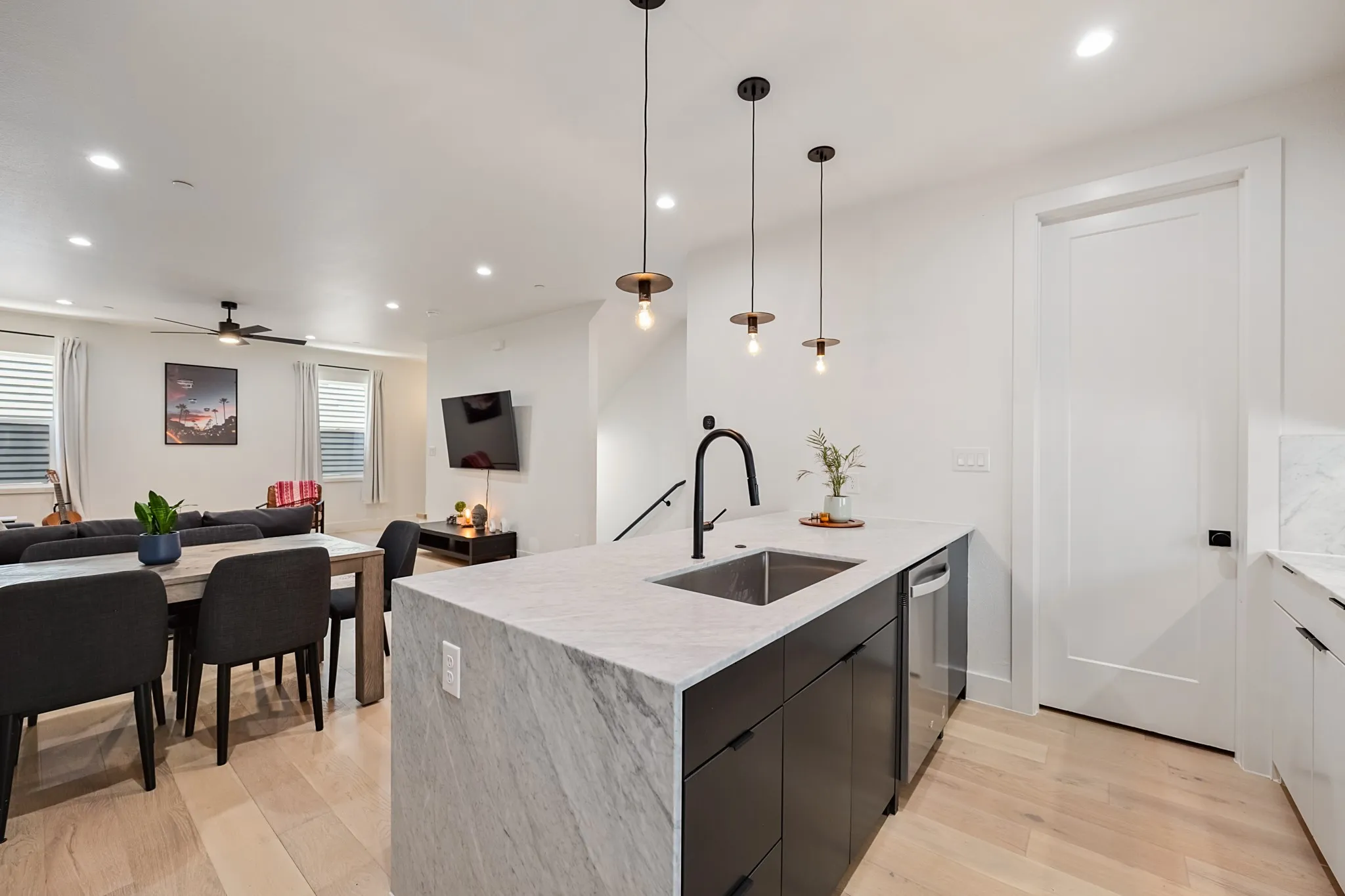 Kitchen island with waterfall countertop, single basin sink, and matte black faucet
