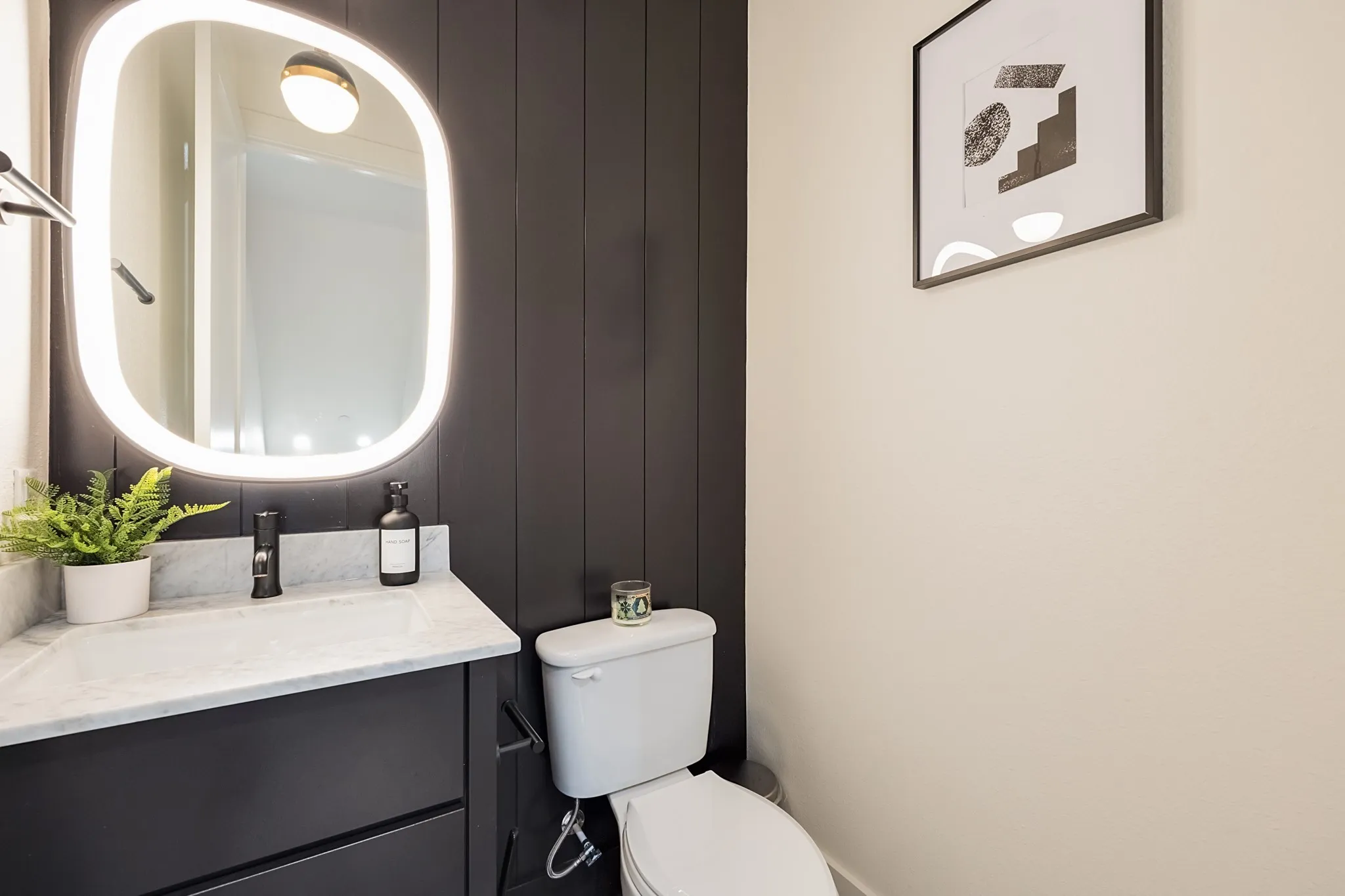 Vanity with stone countertop, integrated sink, and dark cabinetry