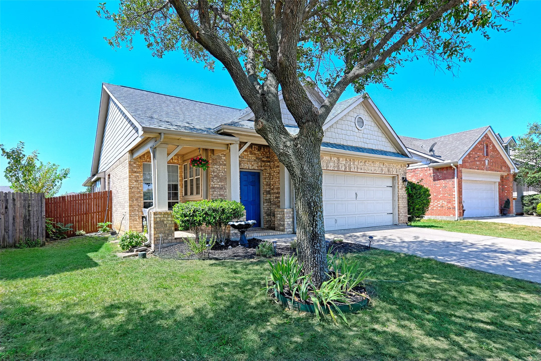 A great angle of the front that shows off the covered porch, pretty brick color, and landscaping.