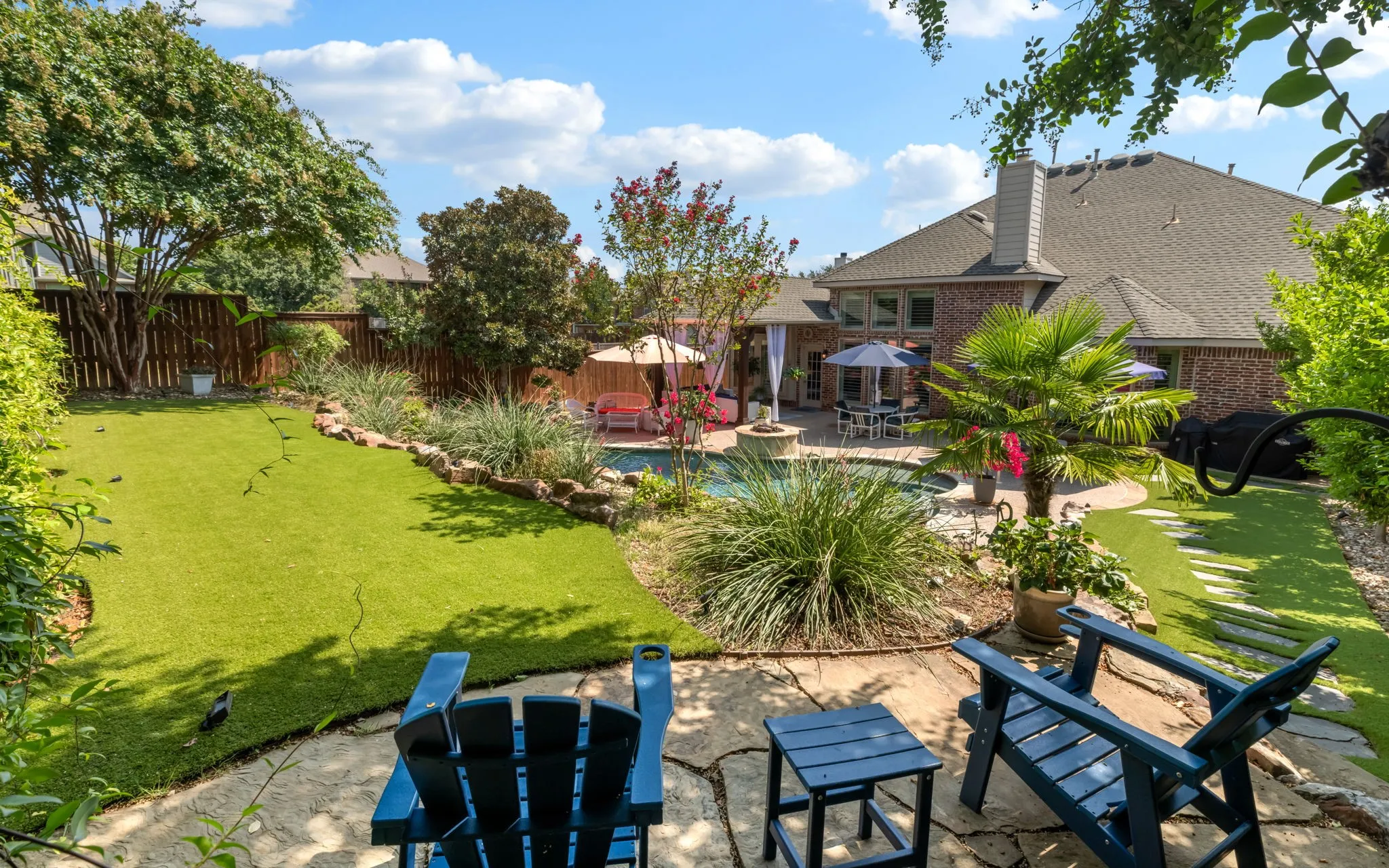 This is the view from the upper terrace. Synthetic turf has been installed throughout the backyard to help maintain the lush surroundings.