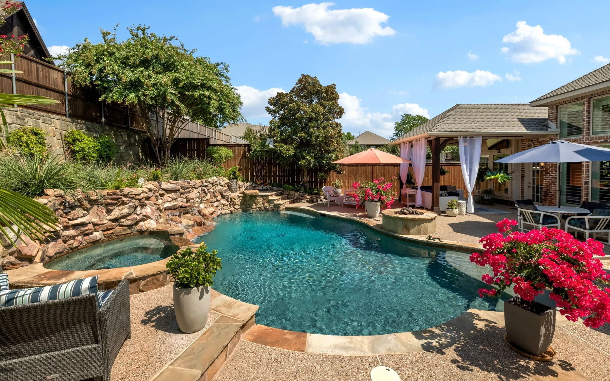 Spa, fire pit, water features and even a built-in diving ledge help make this fabulous back yard a place to unwind and cool off.