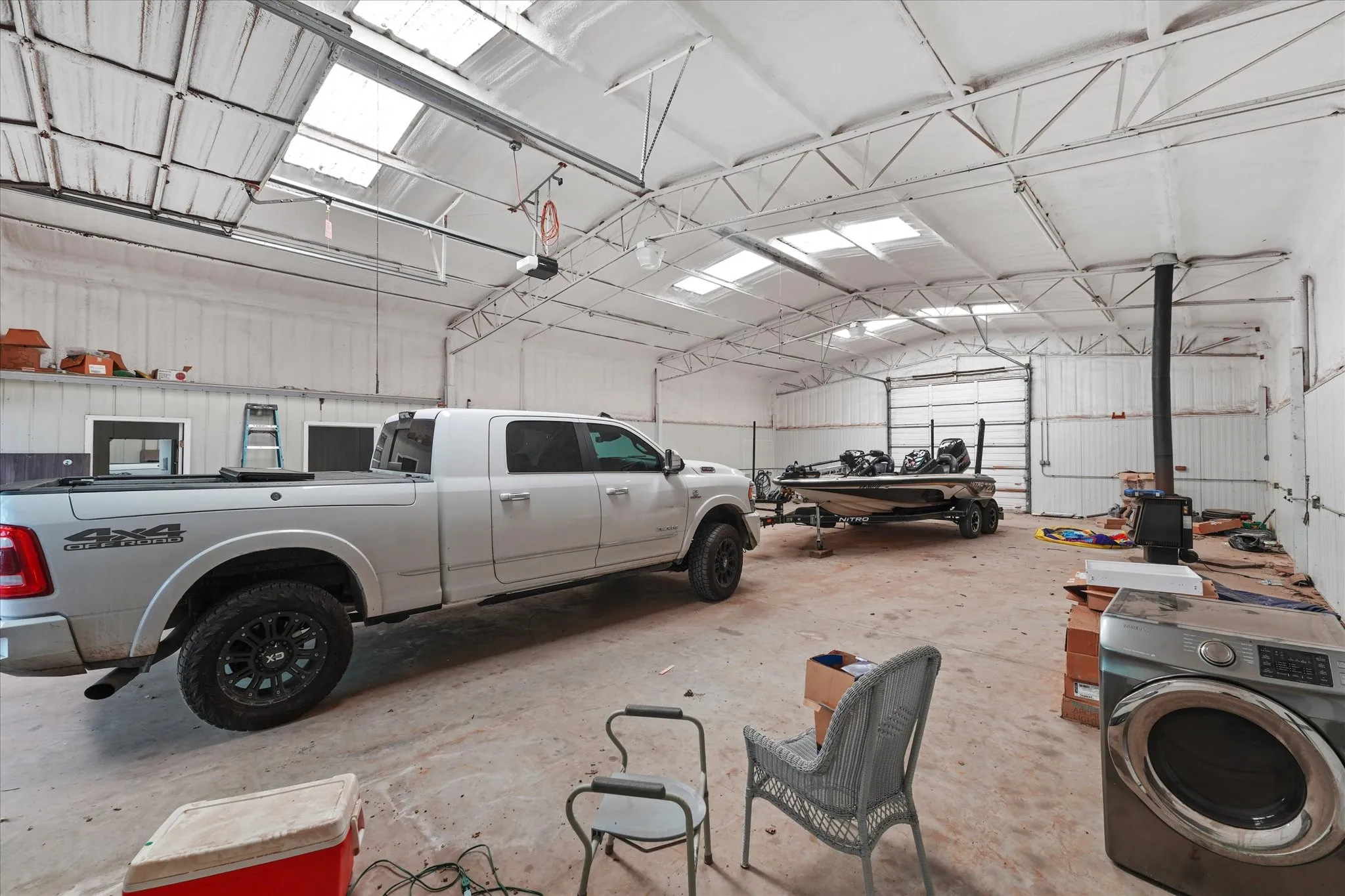 Spacious metal building with a high-pitched ceiling, multiple skylights, and exposed truss work