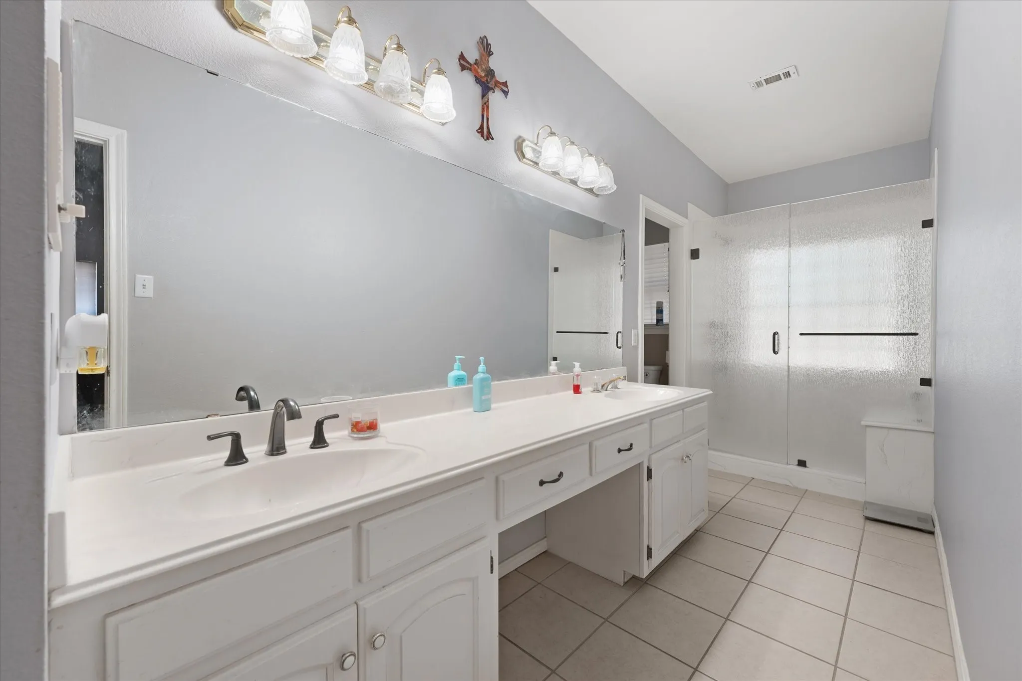 Double vanity with integrated sinks, brushed nickel fixtures, and a large wall-mounted mirror