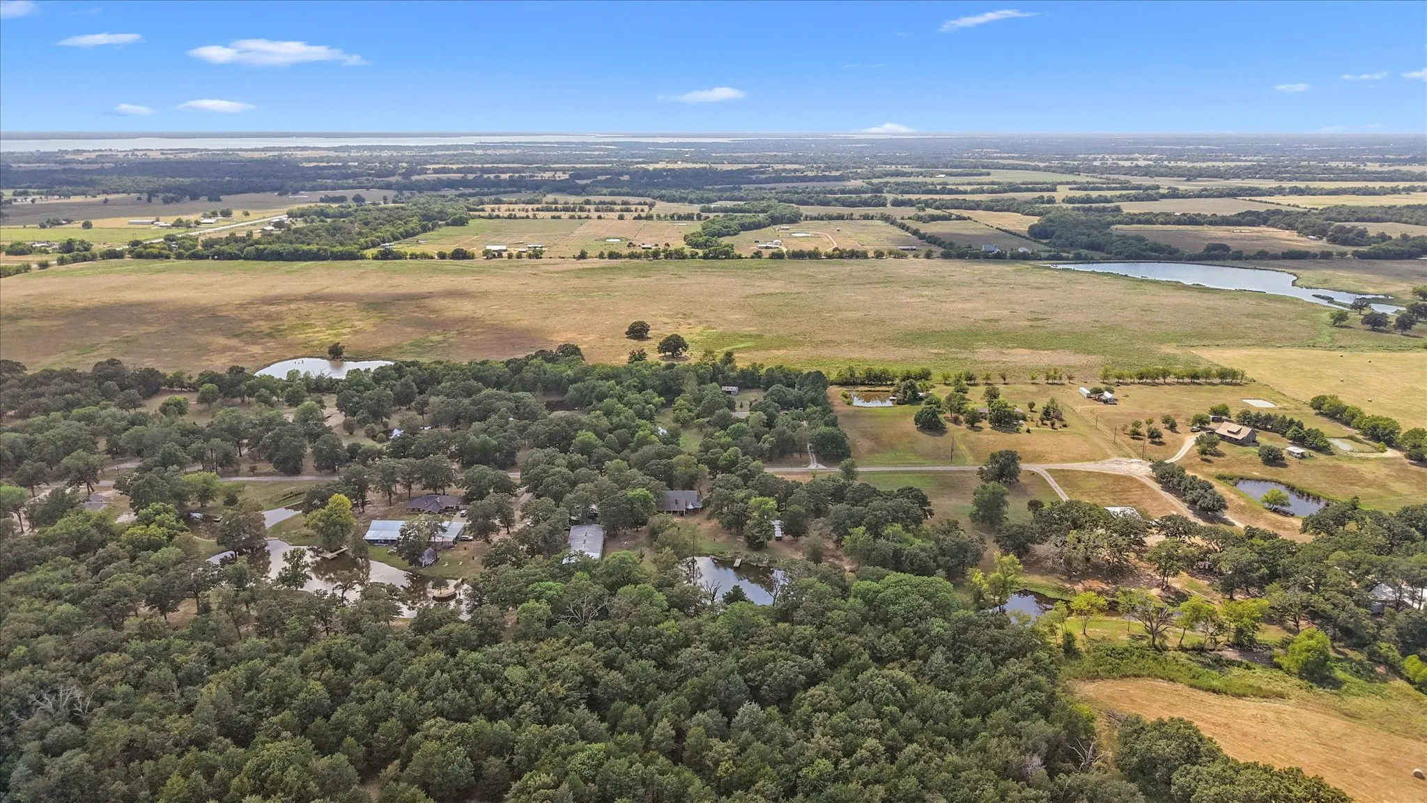Expansive acreage with wooded areas, open fields, and multiple ponds