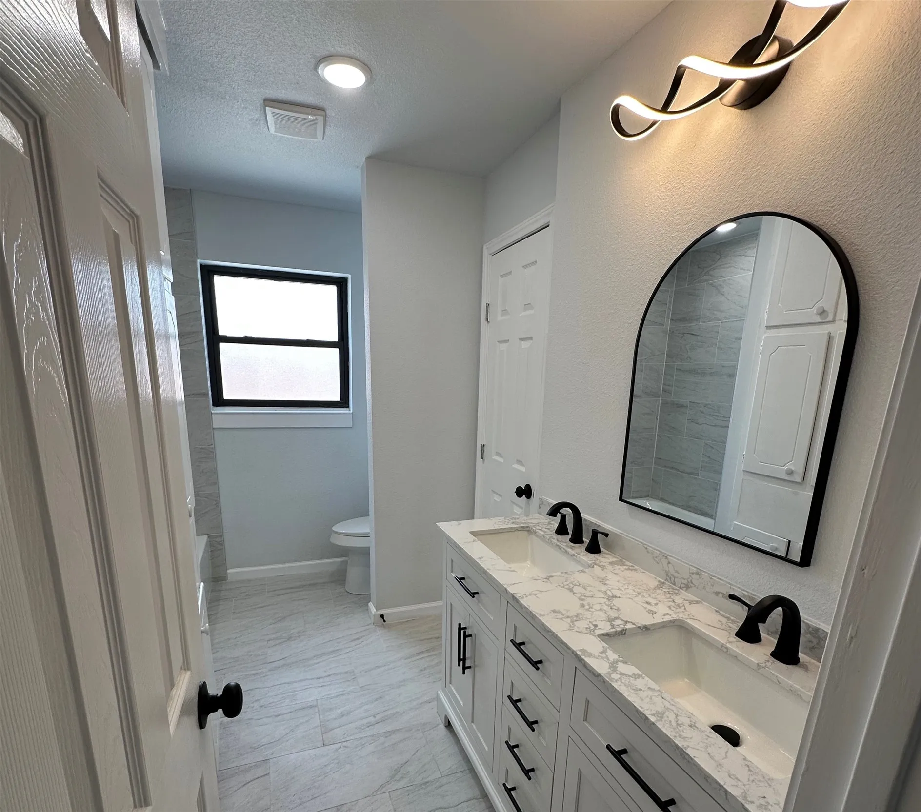 Wood-finish flooring, white walls, double-pane window, ceiling fan with integrated lighting, and bi-fold closet doors