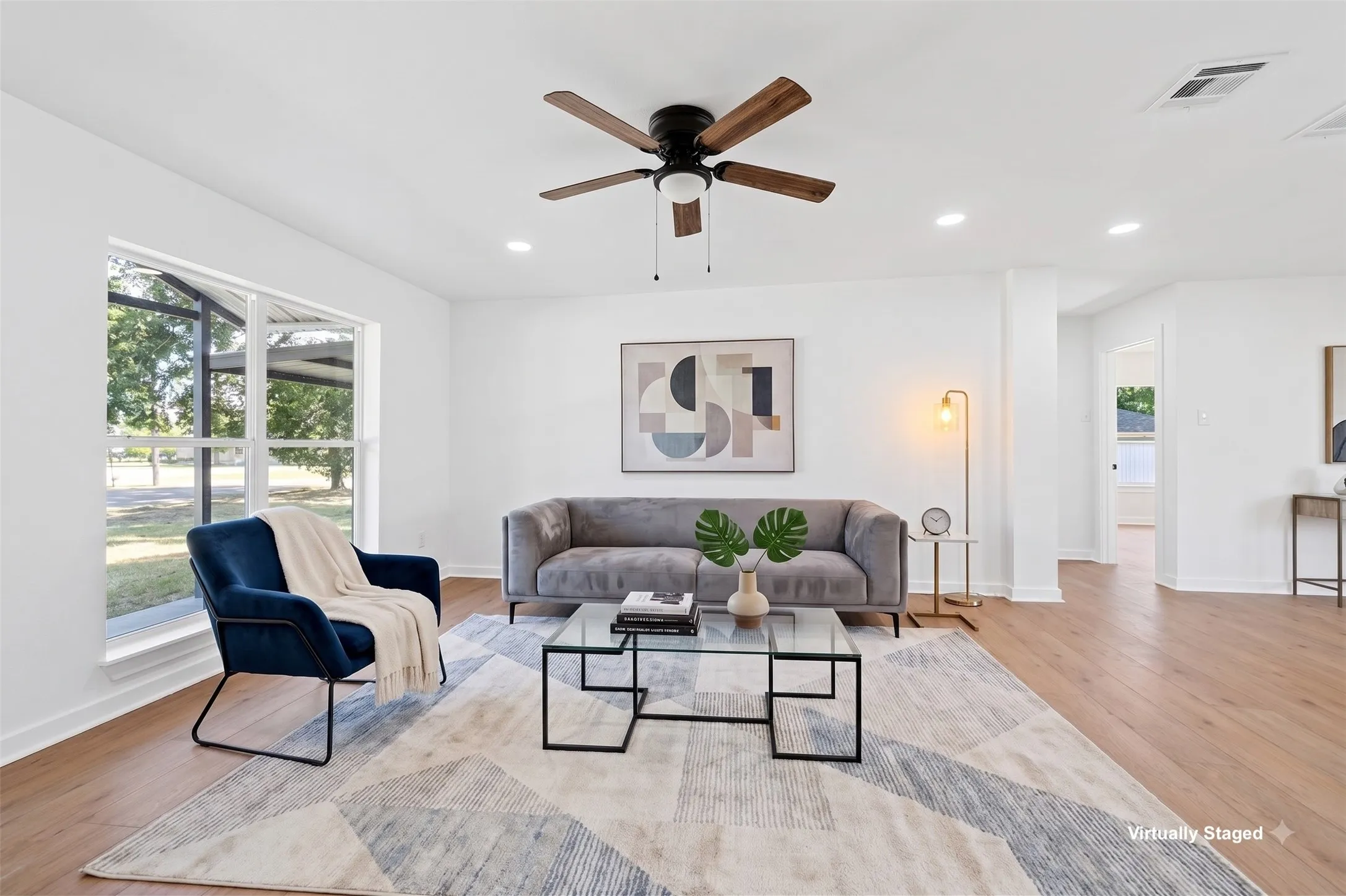 Wood-finish flooring, recessed lighting, ceiling fan, and large windows