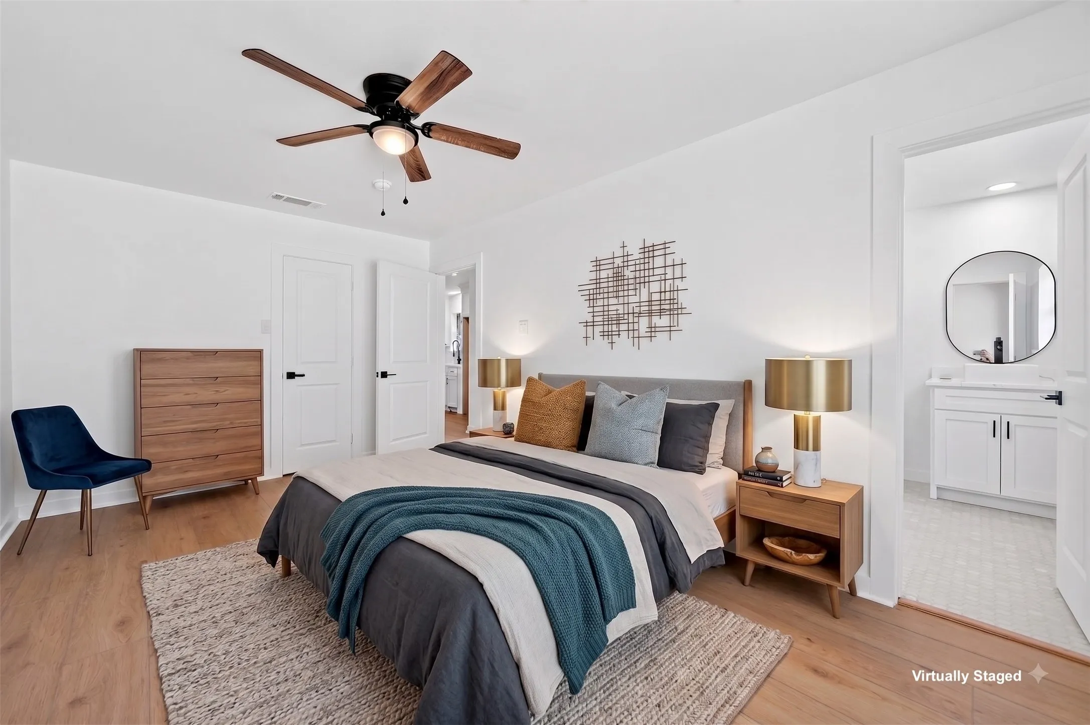 Wood-finish flooring, white paneled doors with black hardware, and a ceiling fan with integrated lighting