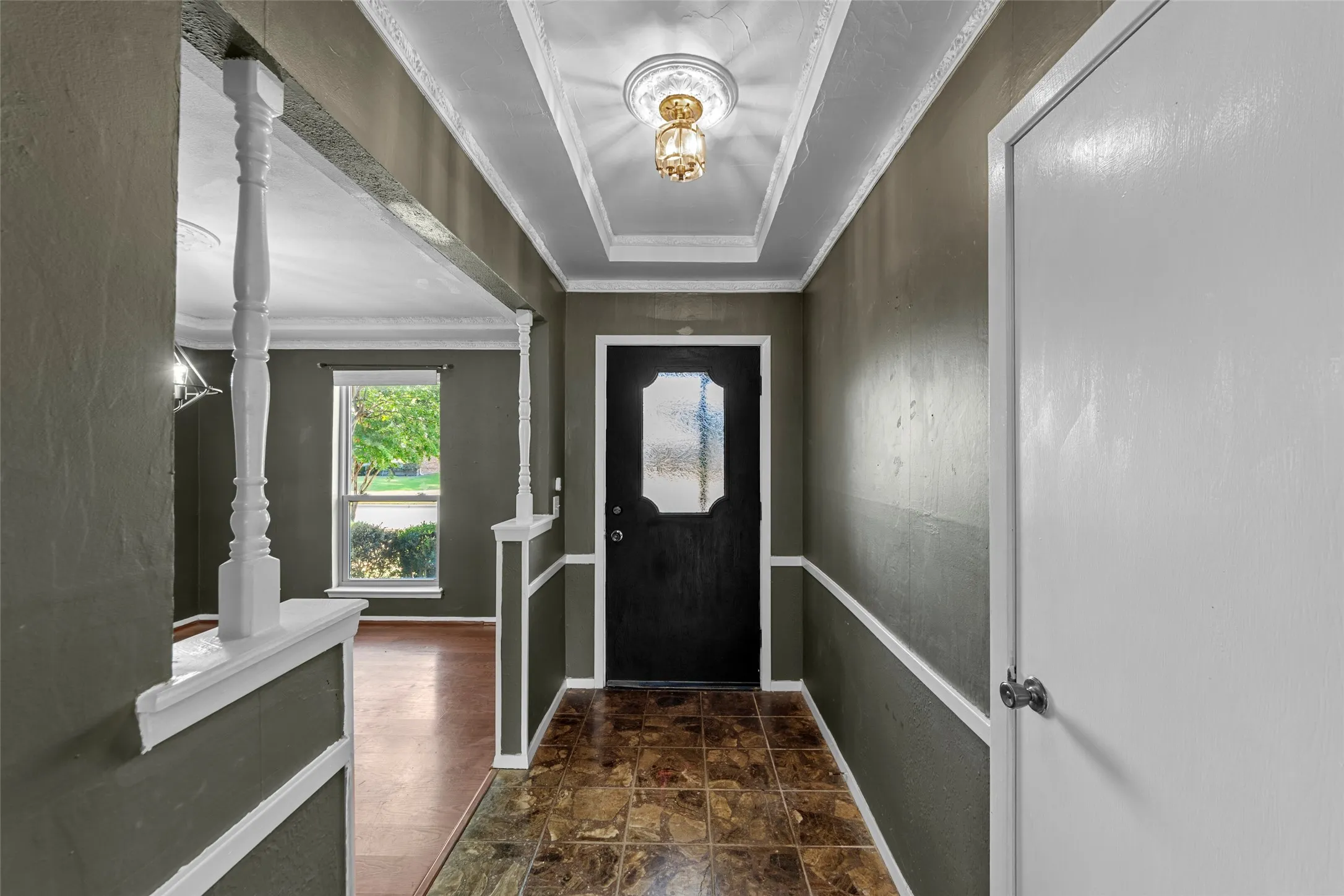 Foyer with tray ceiling, crown molding, and decorative ceiling medallion