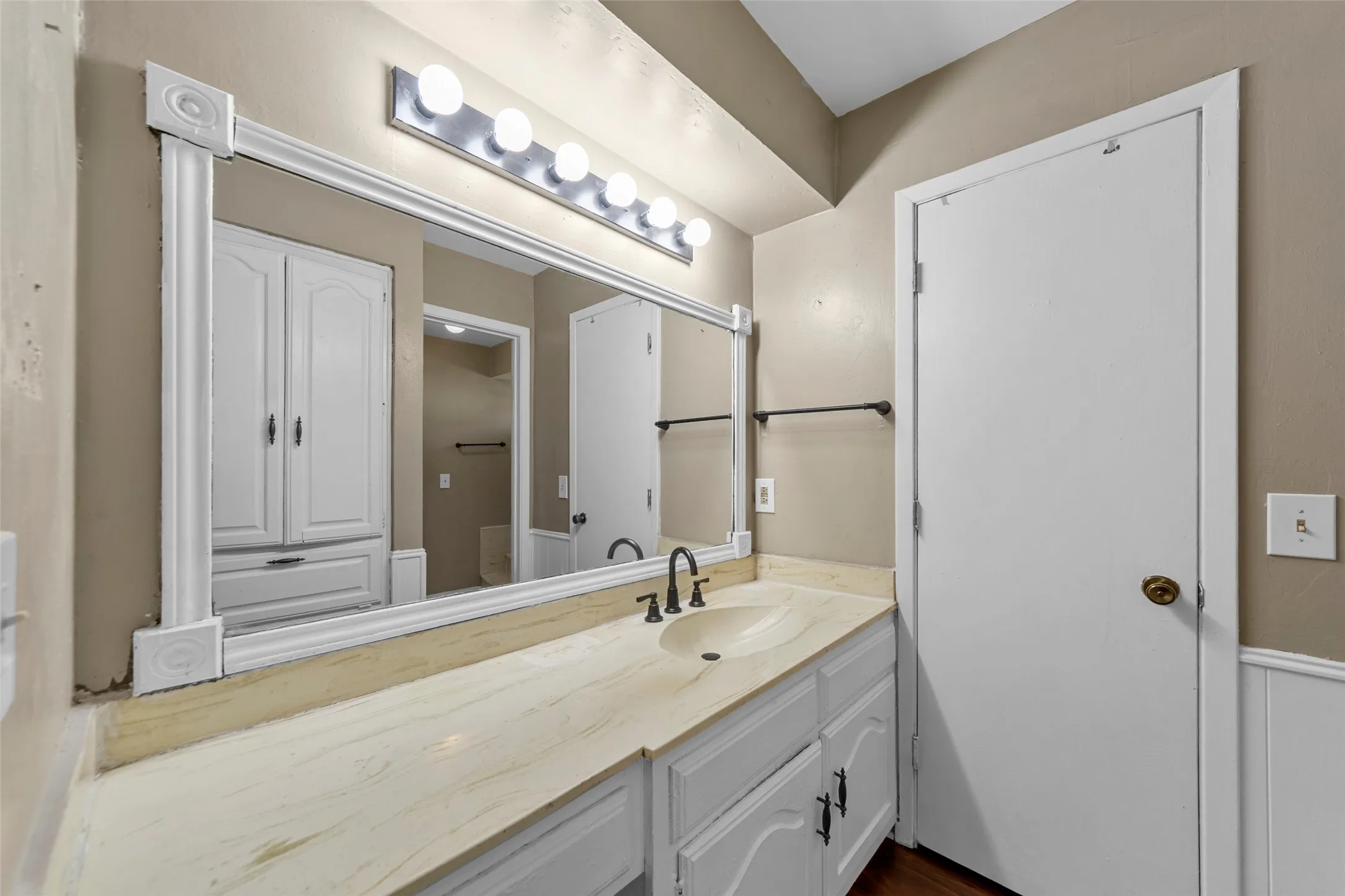 Vanity with a built-in sink, framed mirror, and integrated lighting