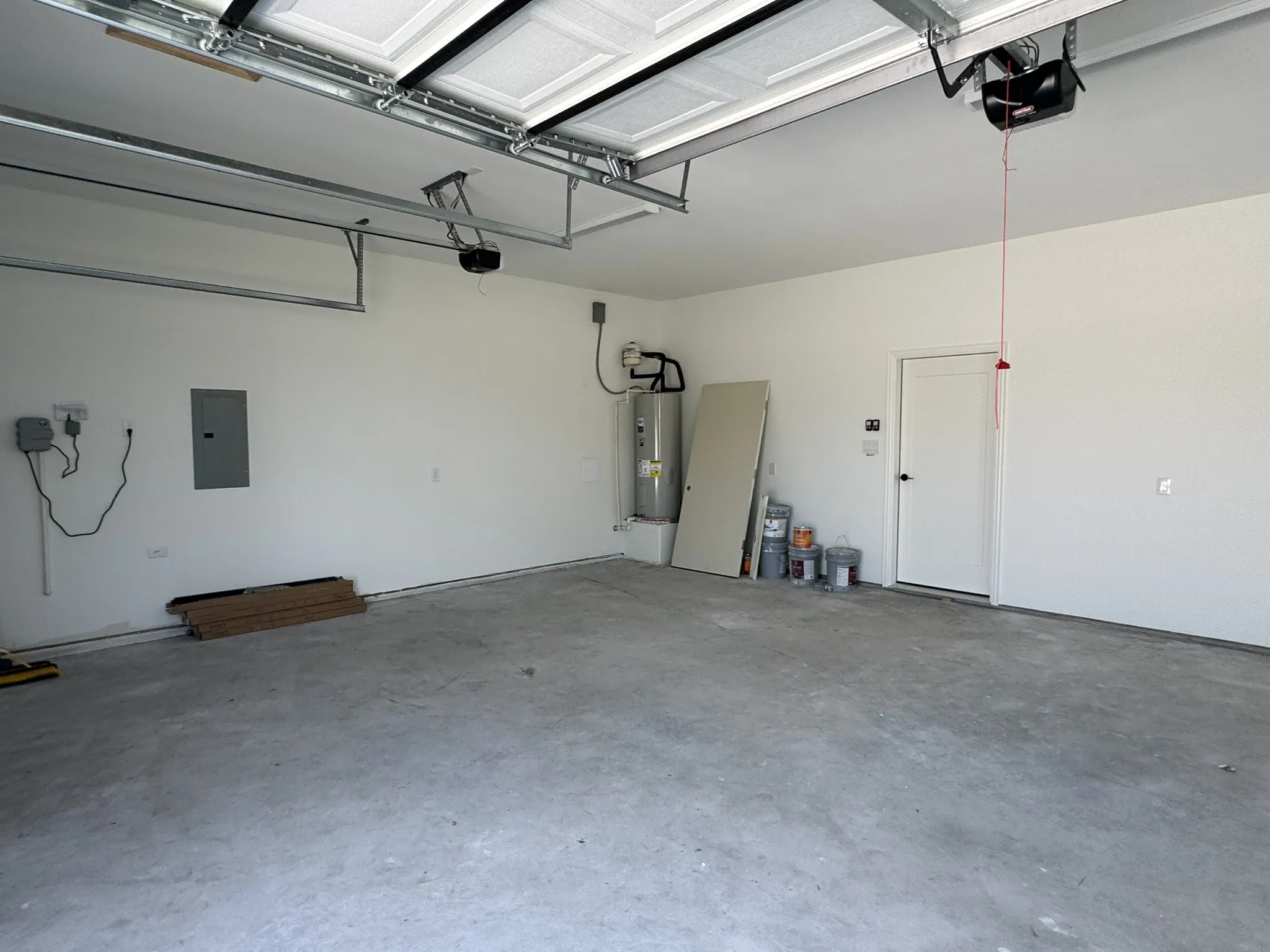 Attached garage with a concrete floor, automated garage door opener, and a side access door