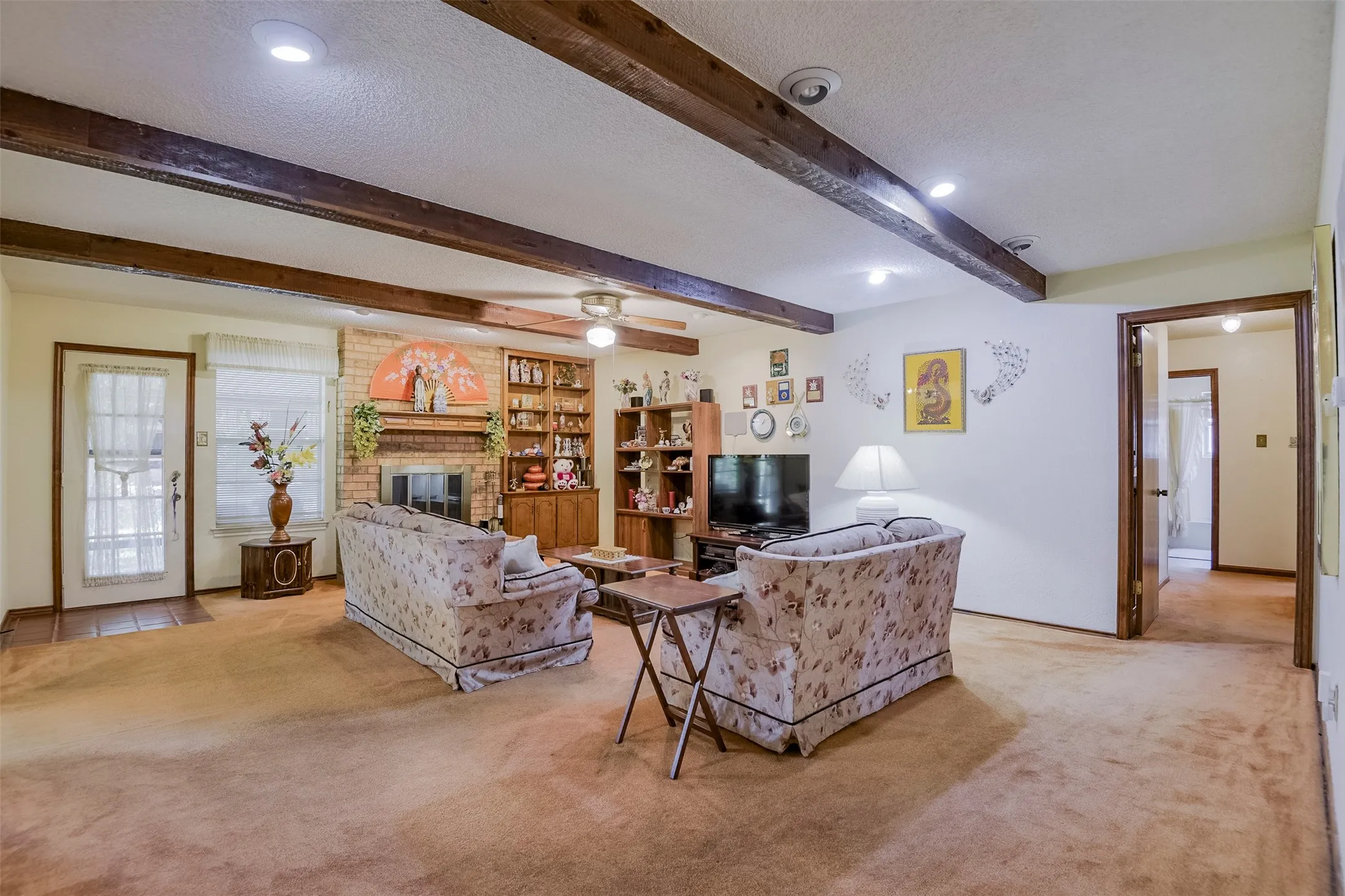 Generously sized den exudes timeless charm with its cedar-beamed ceiling and classic fireplace flanked by display shelves ready to showcase your favorite collection.  The effect is warm, refined and wonderfully understated.