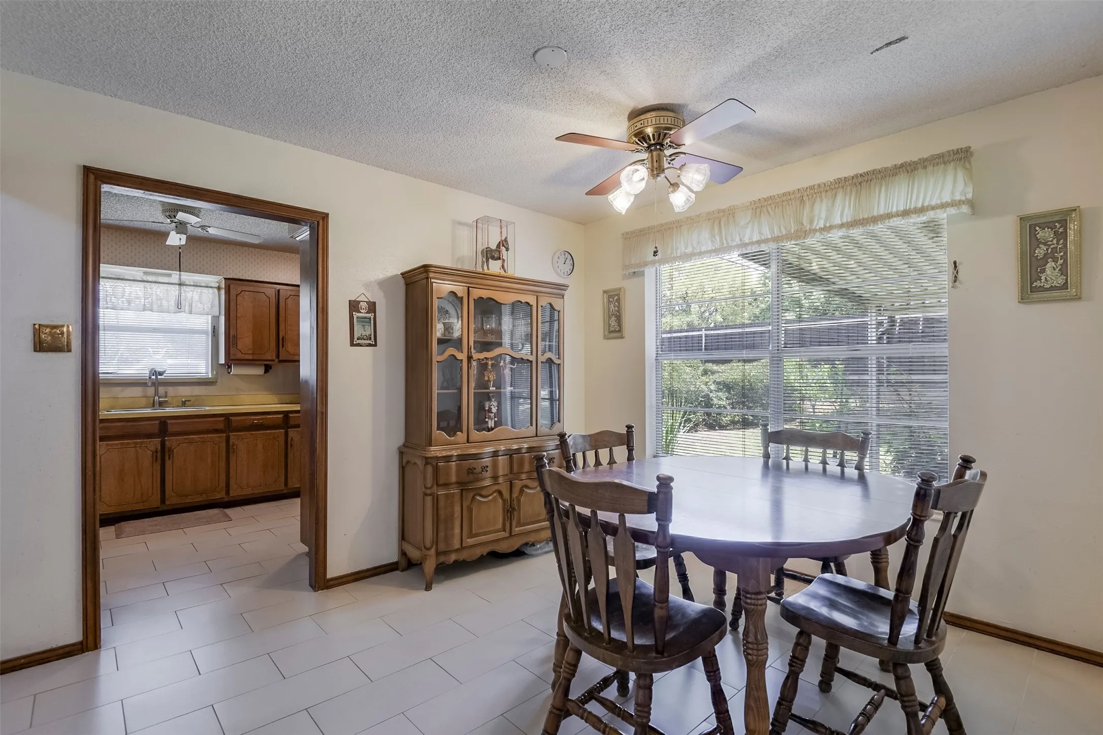Cheerful dining area flows effortlessly into the living space, creating a welcoming connection between it and the expansive kitchen glimpsed beyond. It's also the perfect place for Grandma's cherished hutch or a serving table.