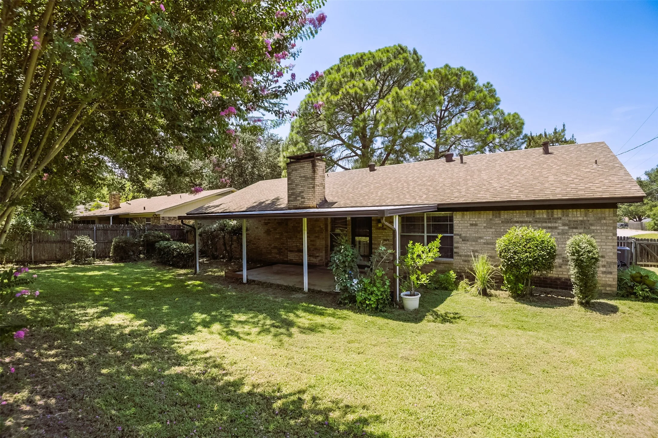 Canopy of towering trees frames the expansive yet tranquil back yard creating a beautiful balance of dappled shade and warm sunshine.