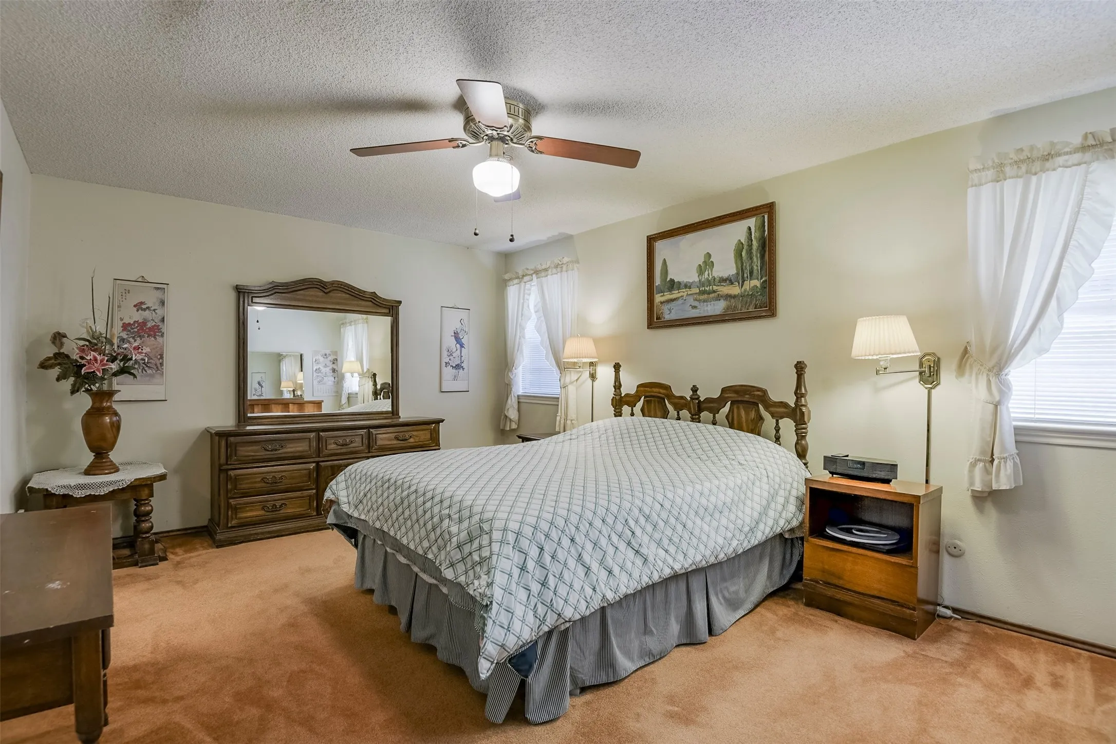 Primary suite fills with natural light from dual windows and offers abundant wall space providing exceptional flexibility for furniture placement creating a comfortable, inviting retreat.