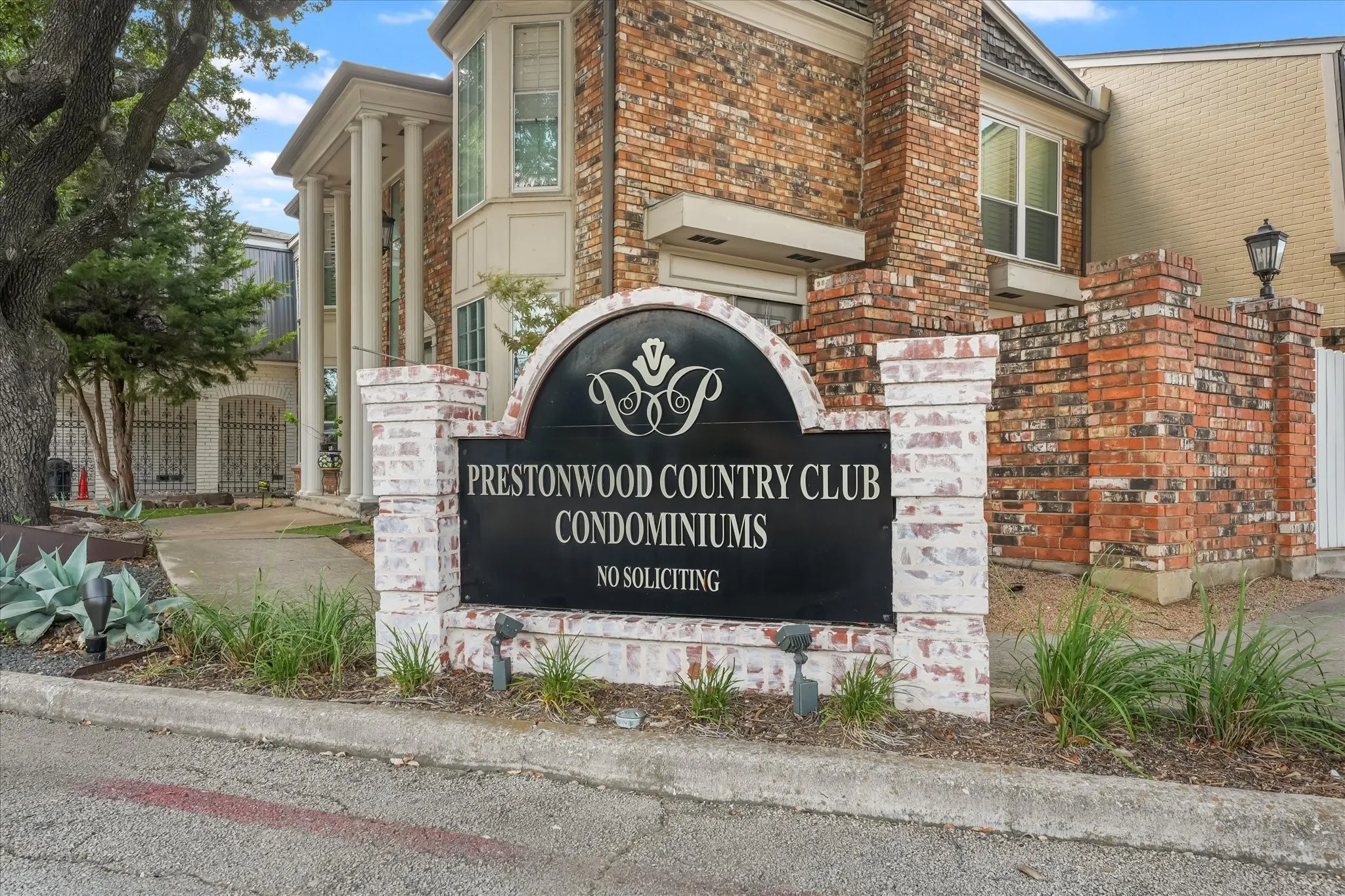 Brick exterior, architectural columns, decorative wrought iron, established landscaping, and an exterior lamp post